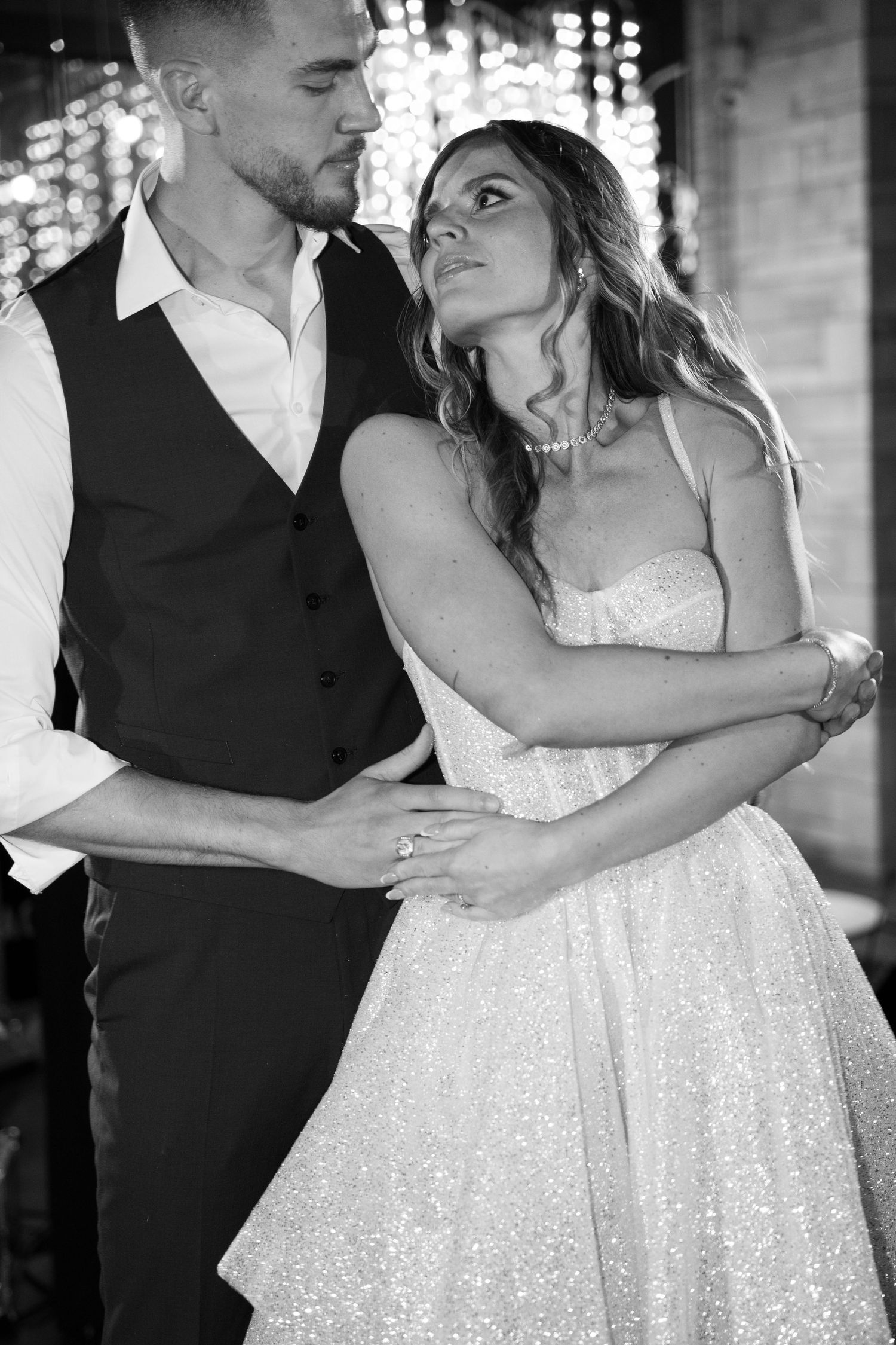 Black and white portrait of bride in strapless gown gazing up at groom during intimate wedding dance. Mallorca wedding photographer and film