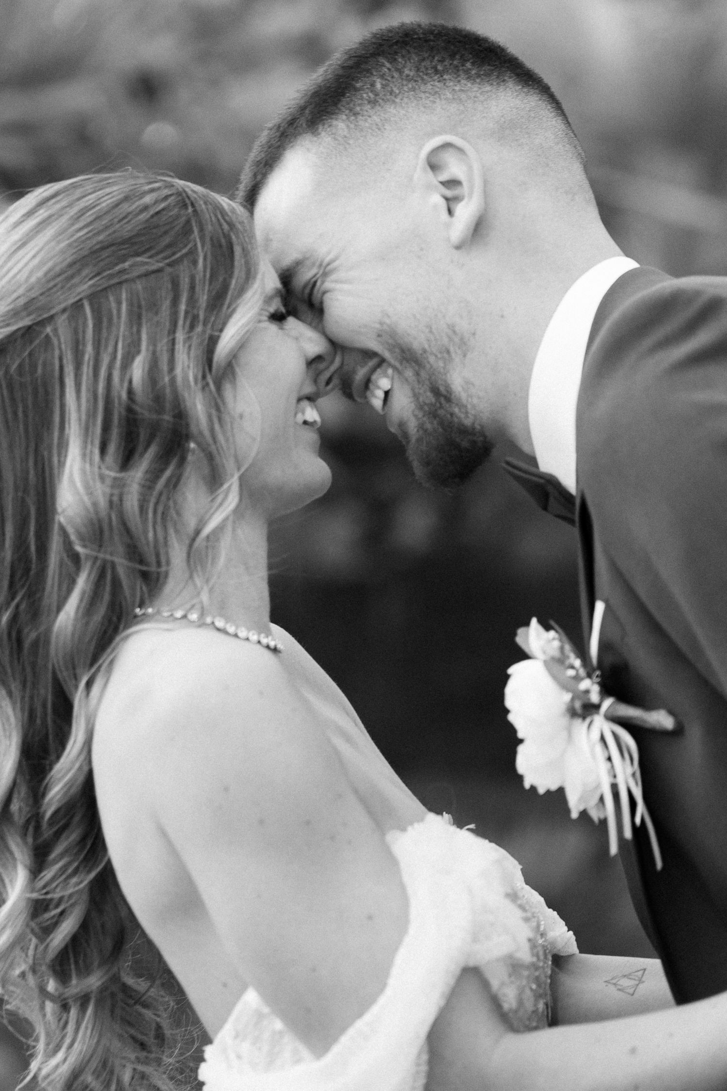 Black and white photo of smiling bride and groom touching foreheads intimately at wedding. Mallorca wedding photographer and filmmaker.