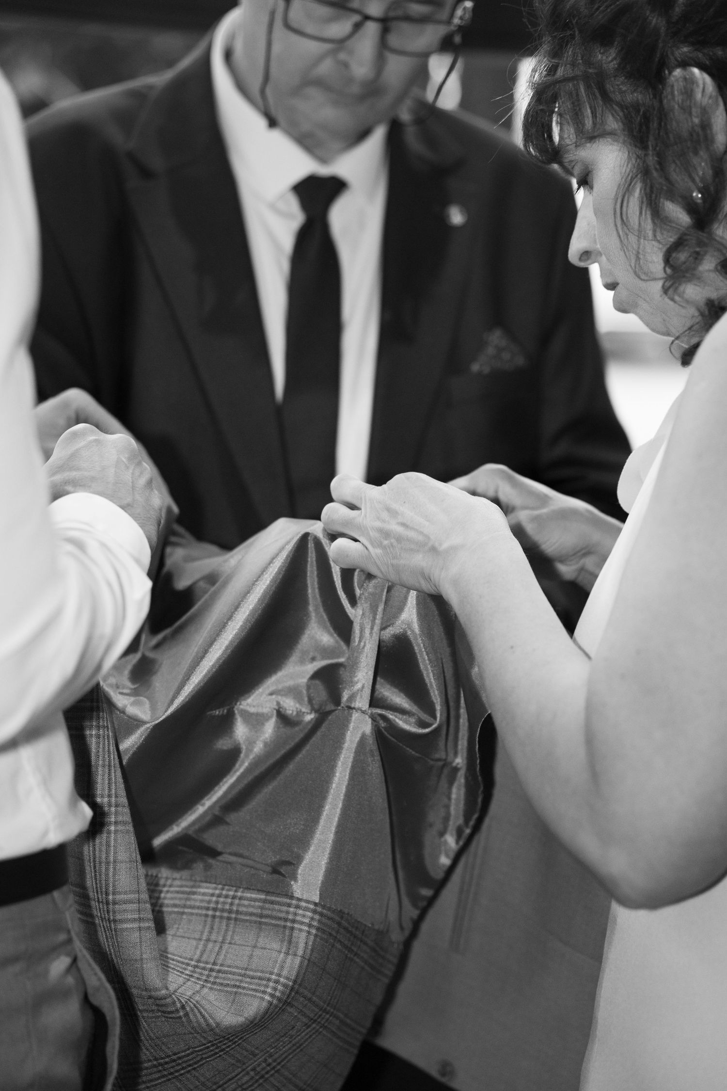 Black and white photo of people examining a bag at a wedding ceremony. Italy wedding photographer and filmmaker