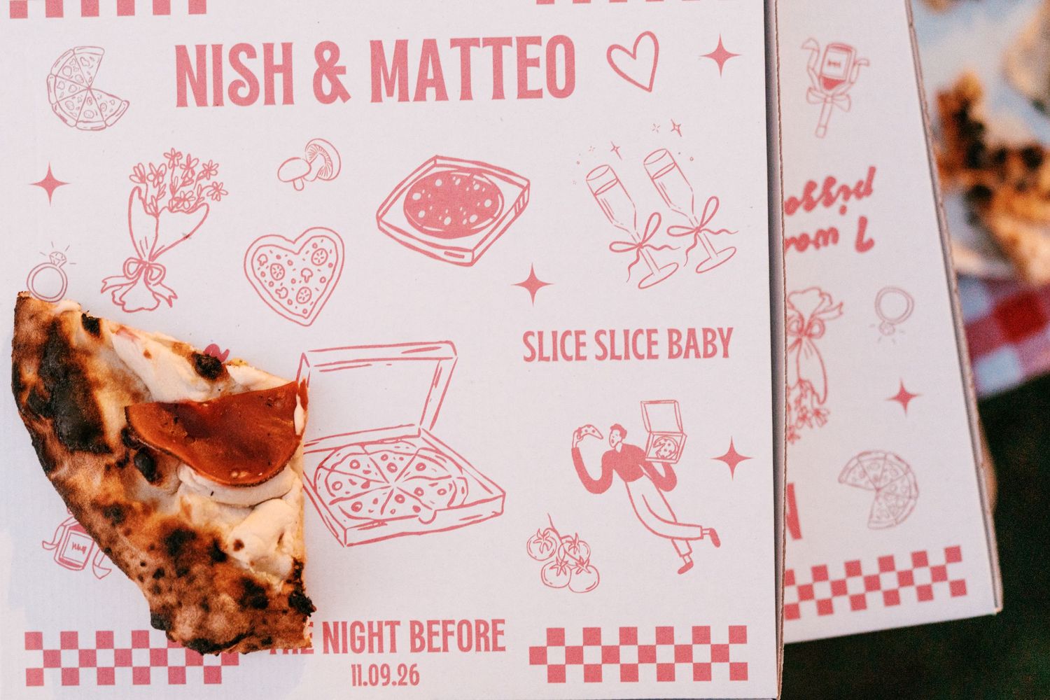 Charred pepperoni pizza slice beside a pink pizza-themed Nish & Matteo 