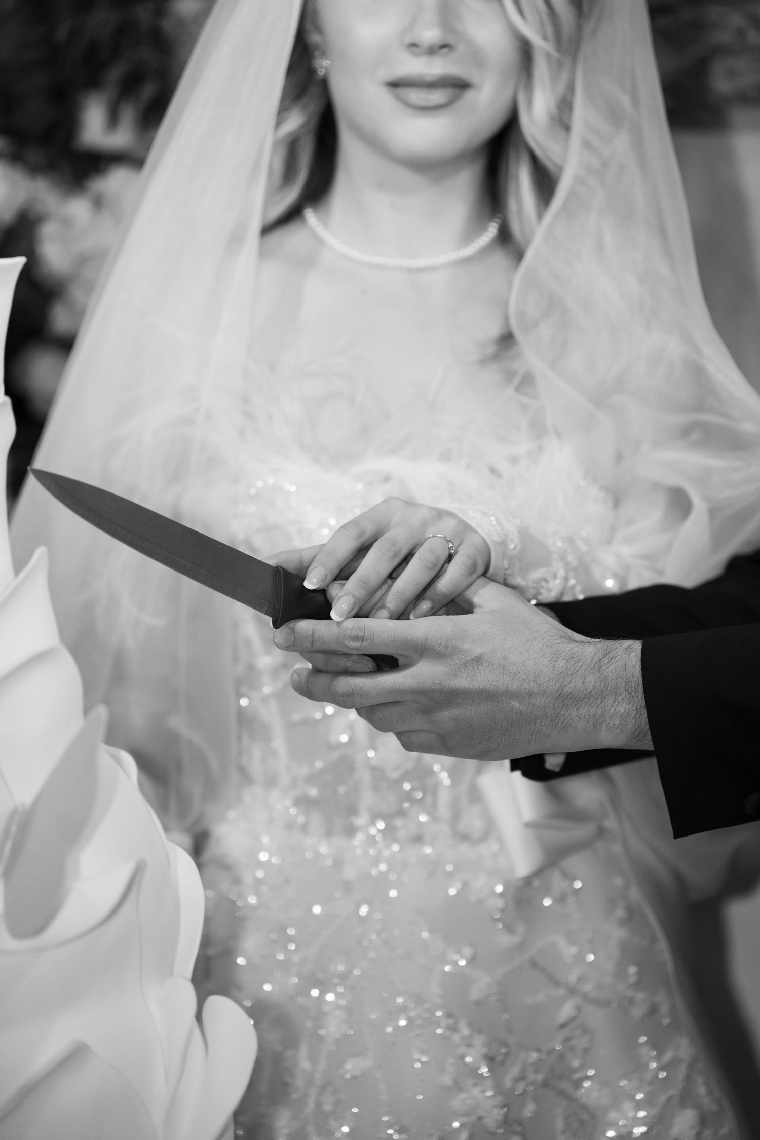 Bride and groom cutting wedding cake together with a knife in black and white photo. Puglia wedding photographer, film