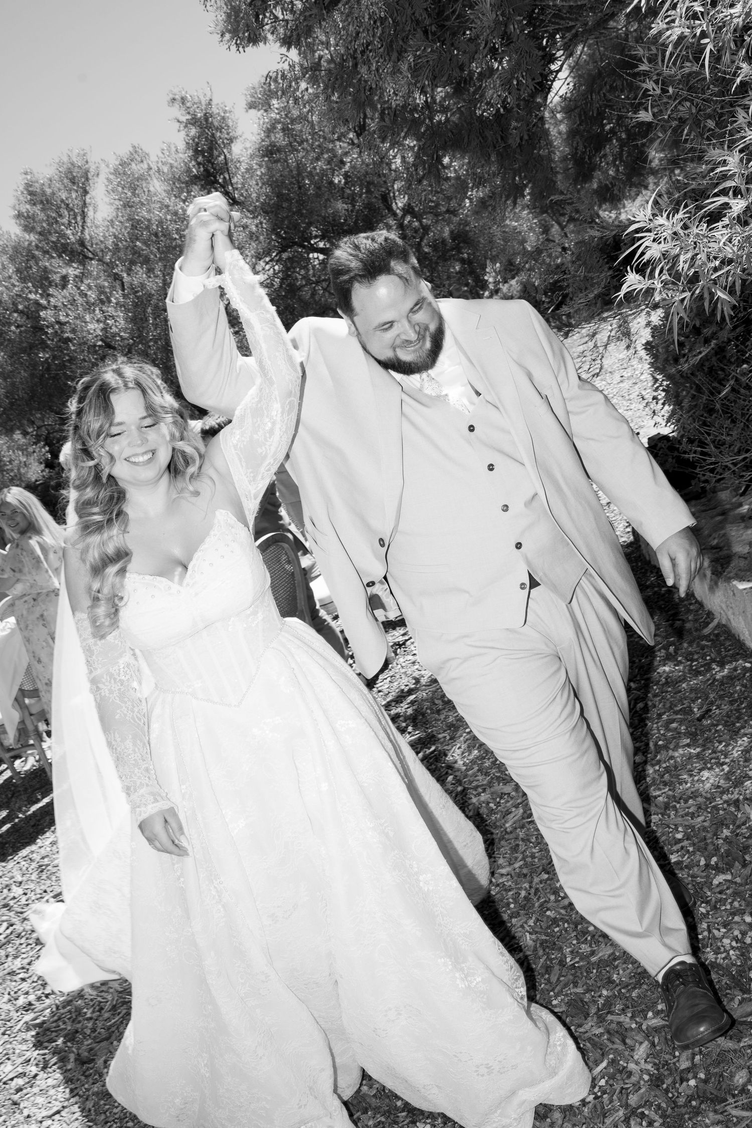 Black and white photo of joyful bride and groom dancing together outdoors on their wedding day in Mallorca.
