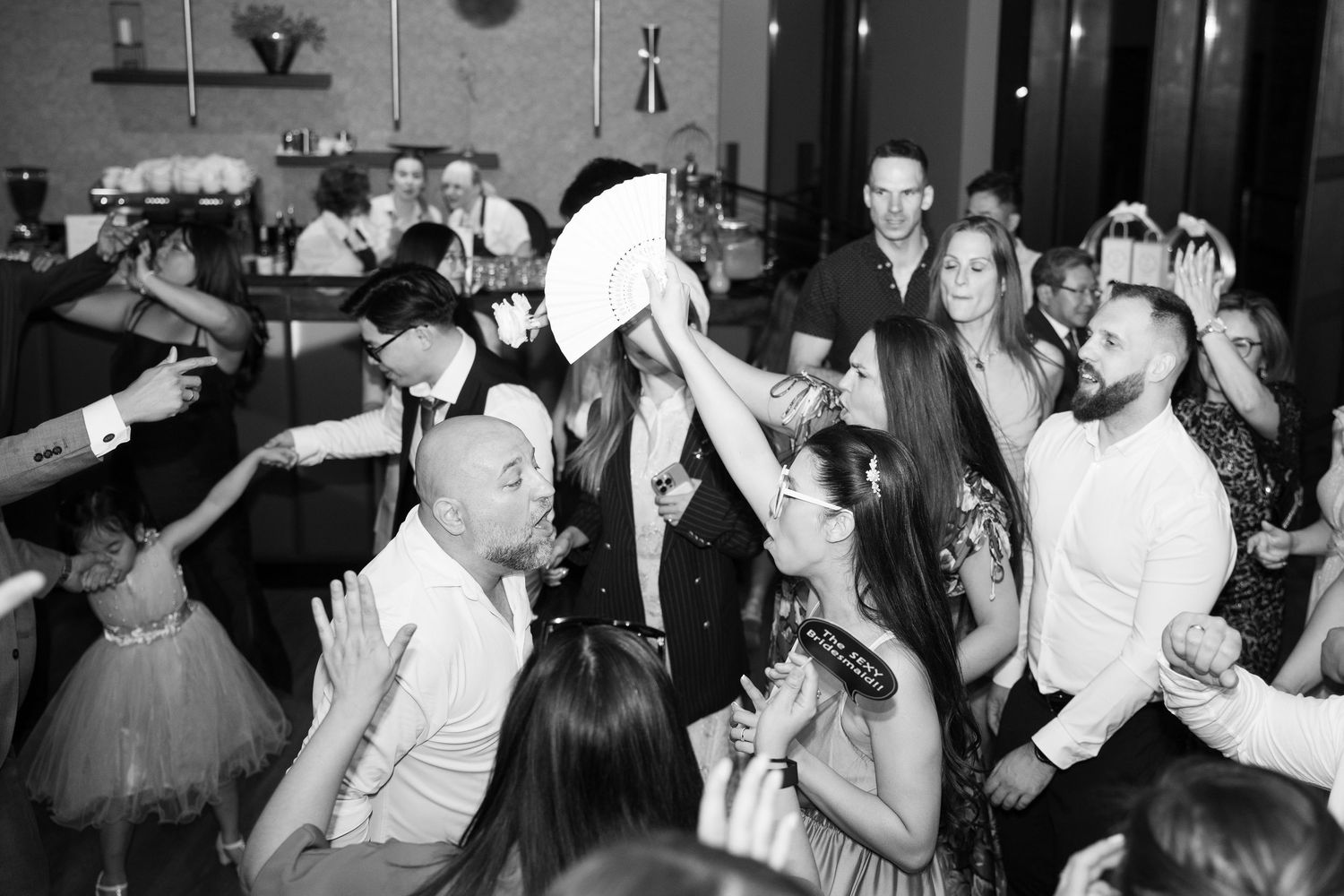 Lively black and white wedding reception dance floor with guests celebrating together. Italy wedding photographer