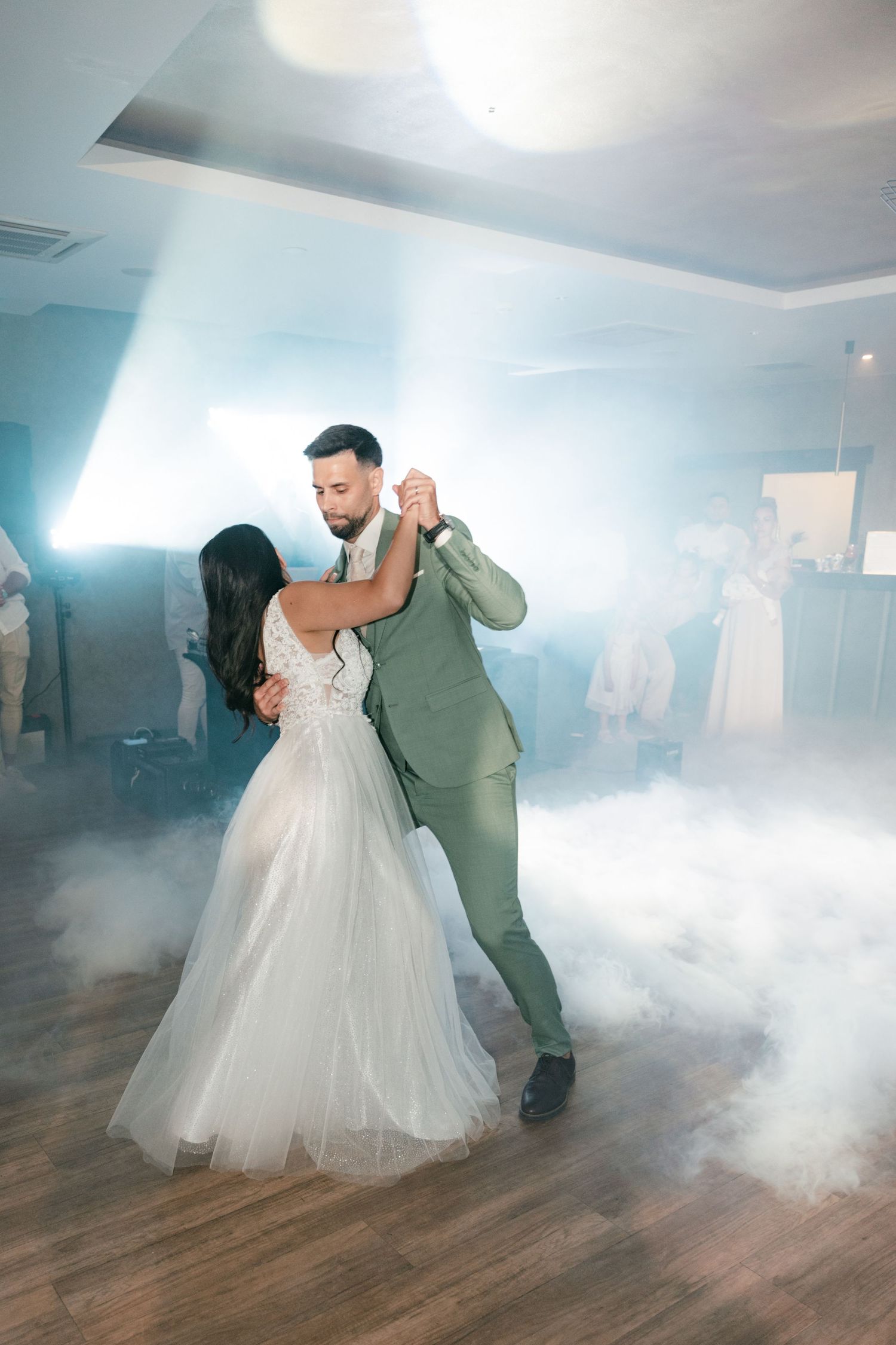 Bride and groom dancing together on foggy wedding reception dance floor. Italy wedding photographer and filmmaker