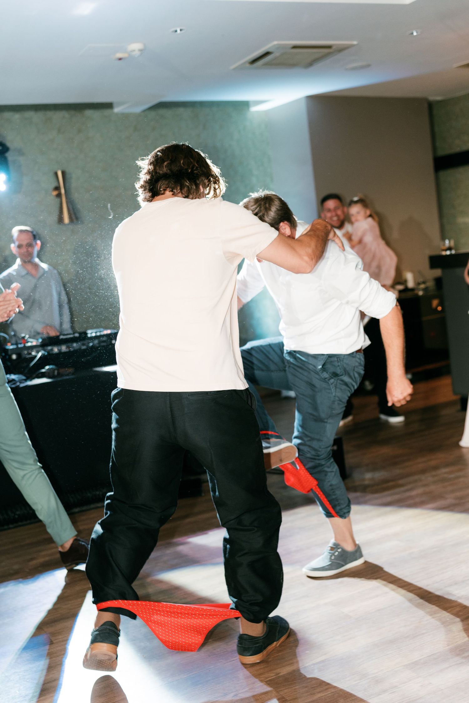 Wedding guests energetically dancing and celebrating on the dance floor at the reception. Italy wedding photographer and filmmaker