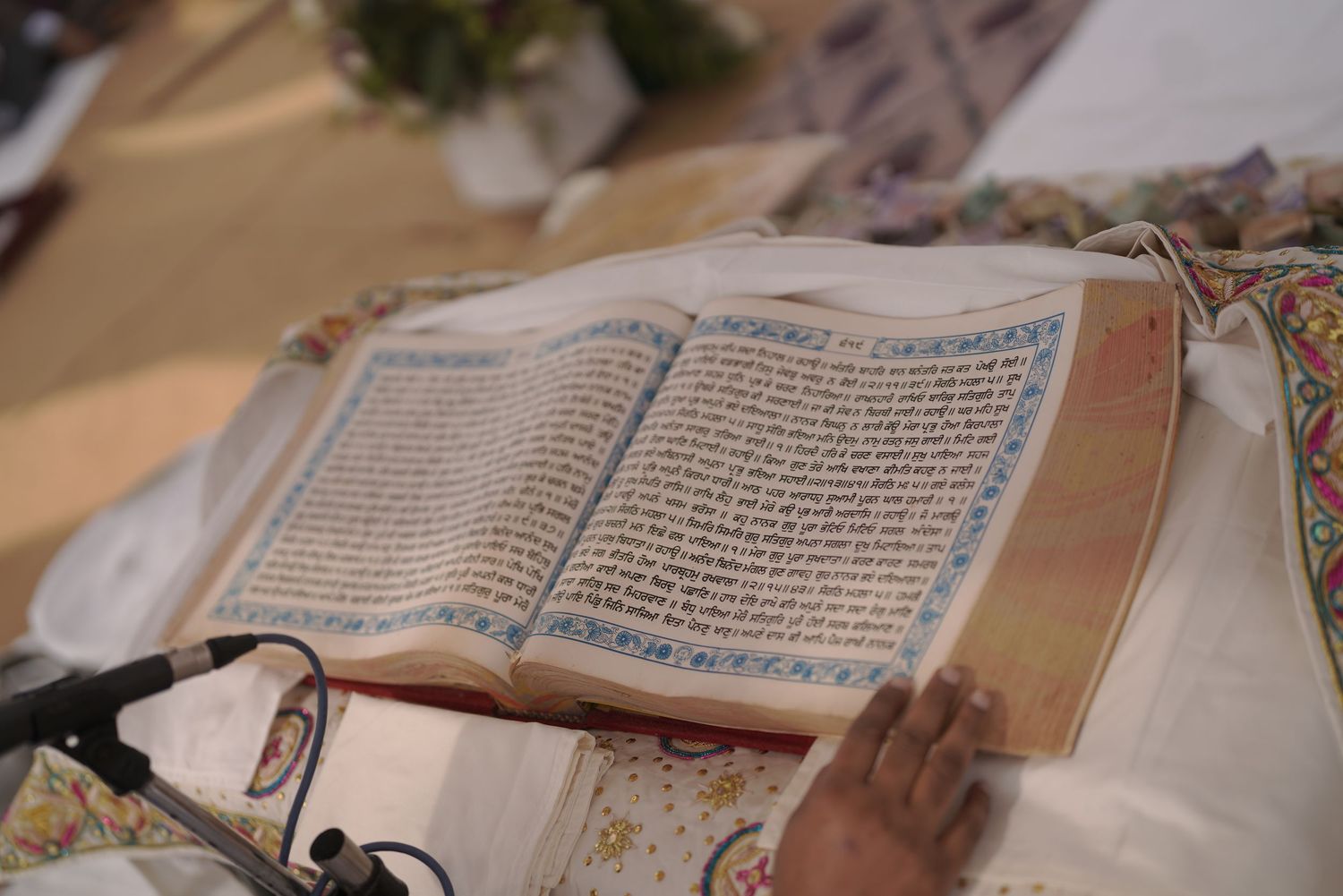 A decorated Sikh holy scripture, the Guru Granth Sahib, open during a wedding ceremony.