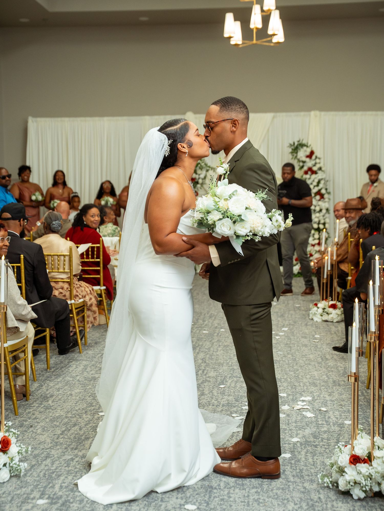 Kayela and Isaac share a kiss during their wedding ceremony, photographed by ClearPixel Media.