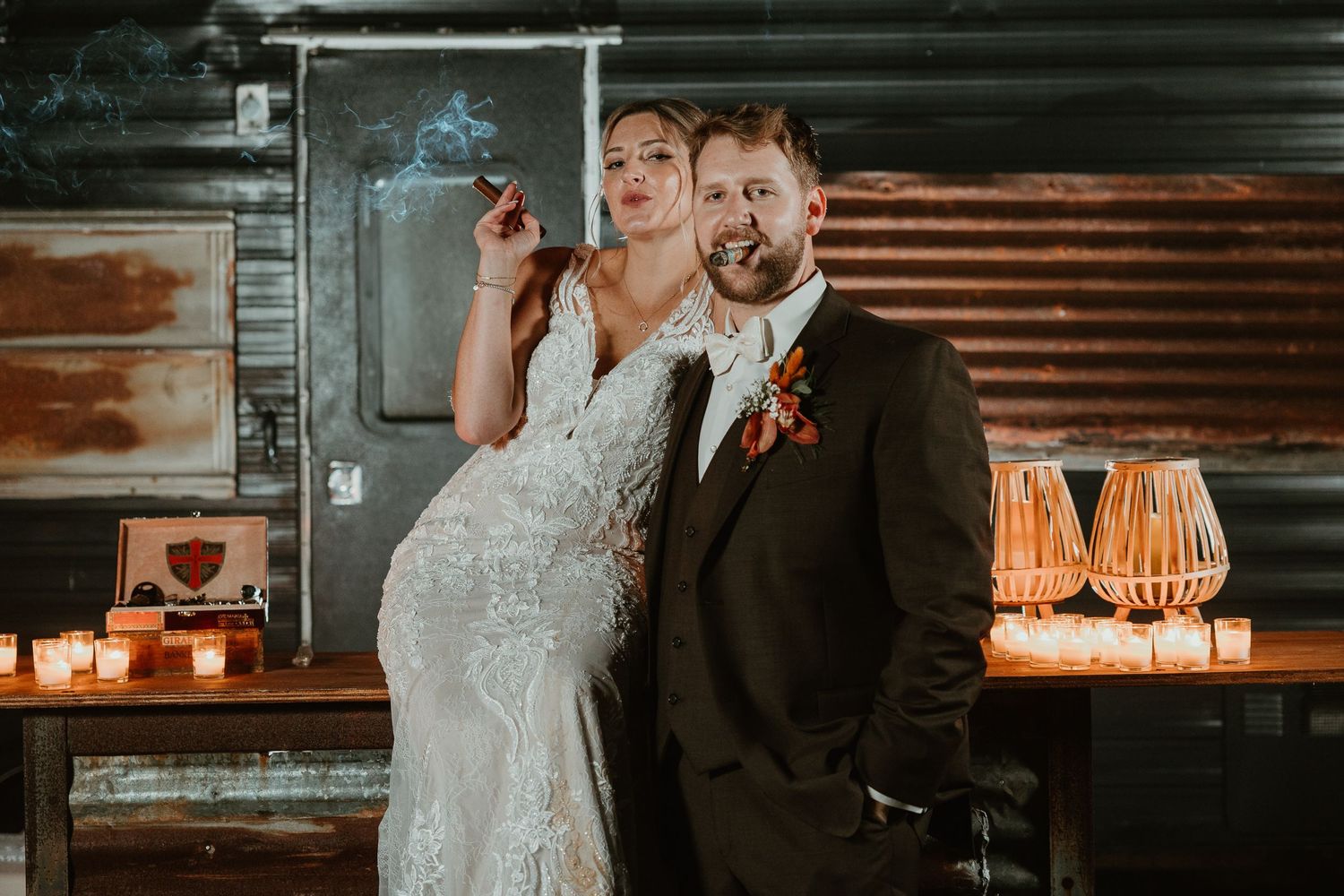 Moody wedding portrait with industrial backdrop and candlelight atmosphere.