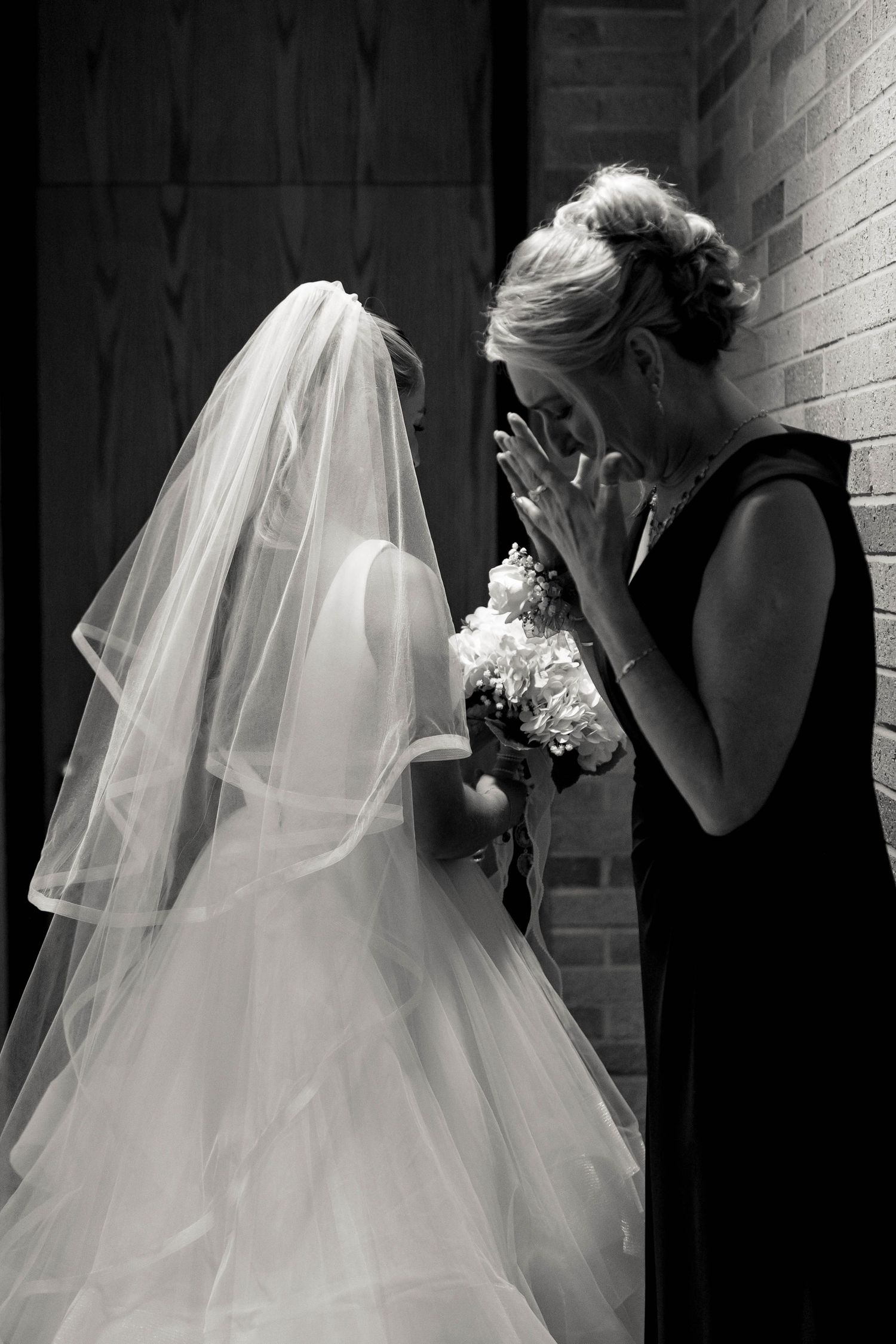A romantic black and white photo sequence of a bride and groom sharing an intimate first kiss at their wedding ceremony.