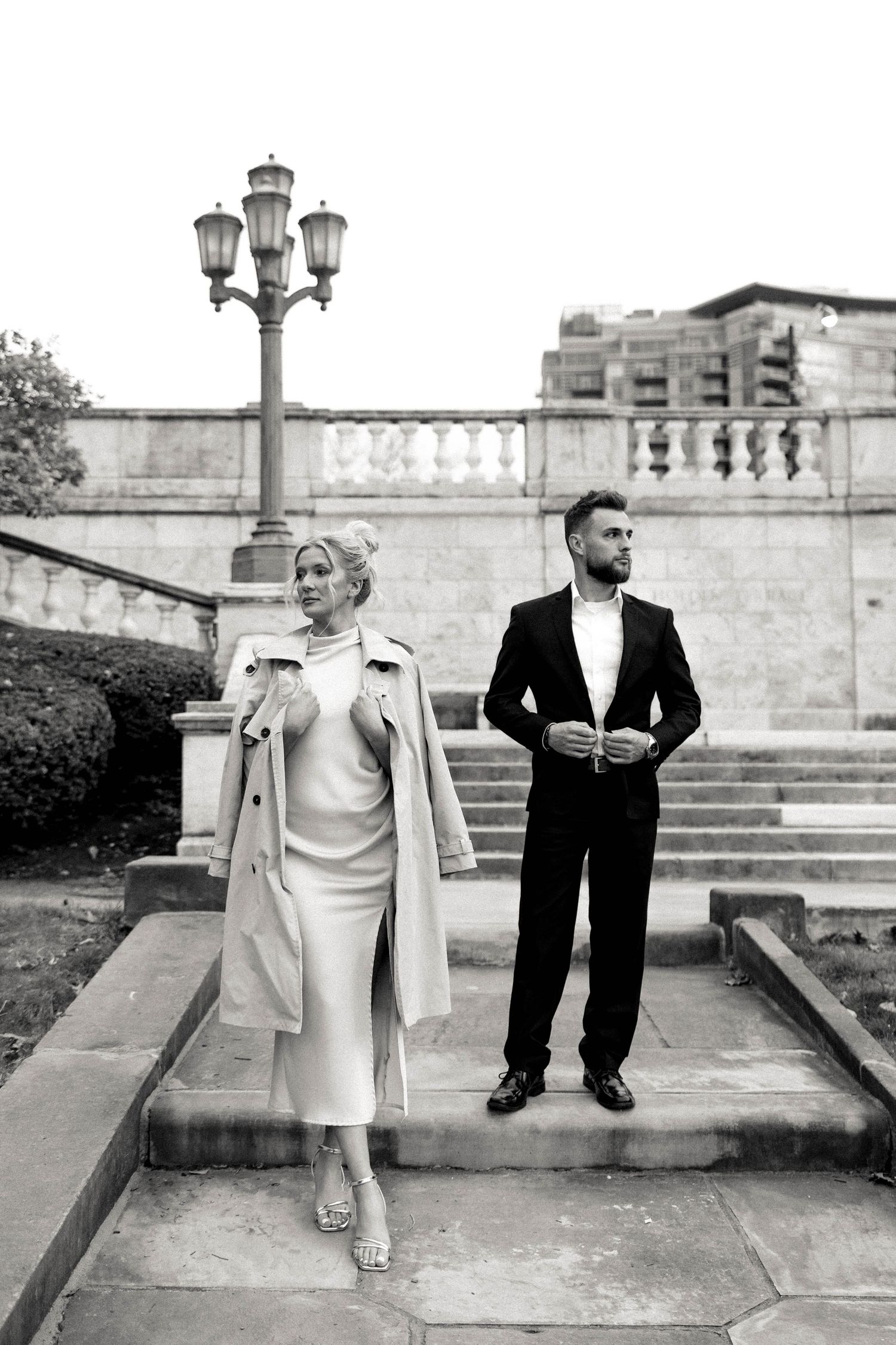 Classic black and white portrait of couple in elegant attire on stone steps with vintage lamp post. Cleveland, OH