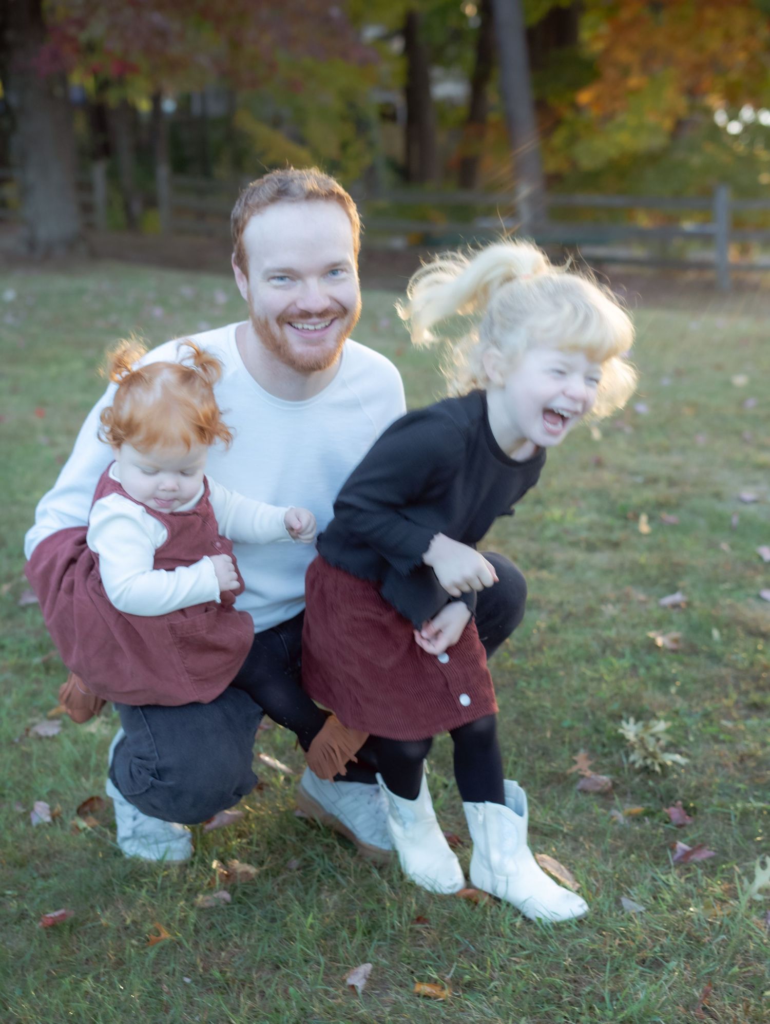 A heartwarming moment of laughter and joy captured outdoors during autumn.