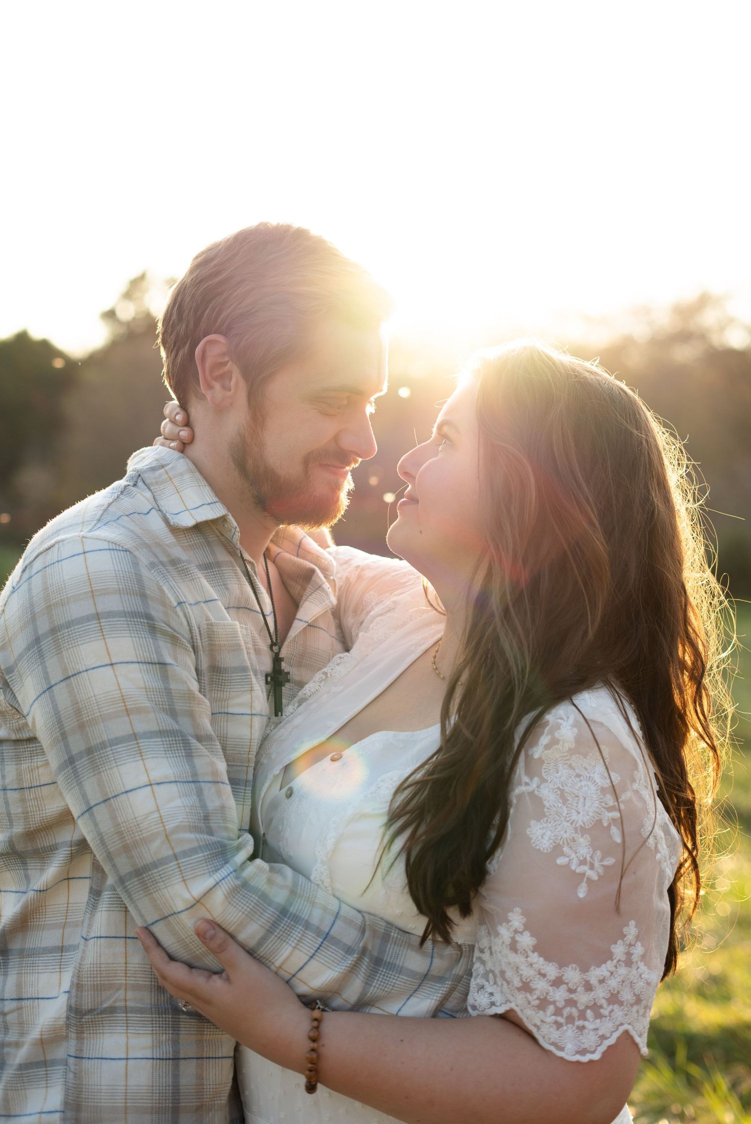 Sunlit portrait in a field with golden backlight and soft expressions.