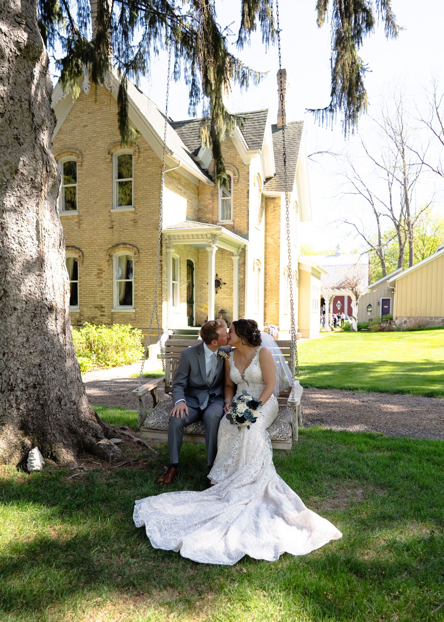 A series of romantic outdoor portraits showing a couple embracing under tall trees near a historic yellow brick building.