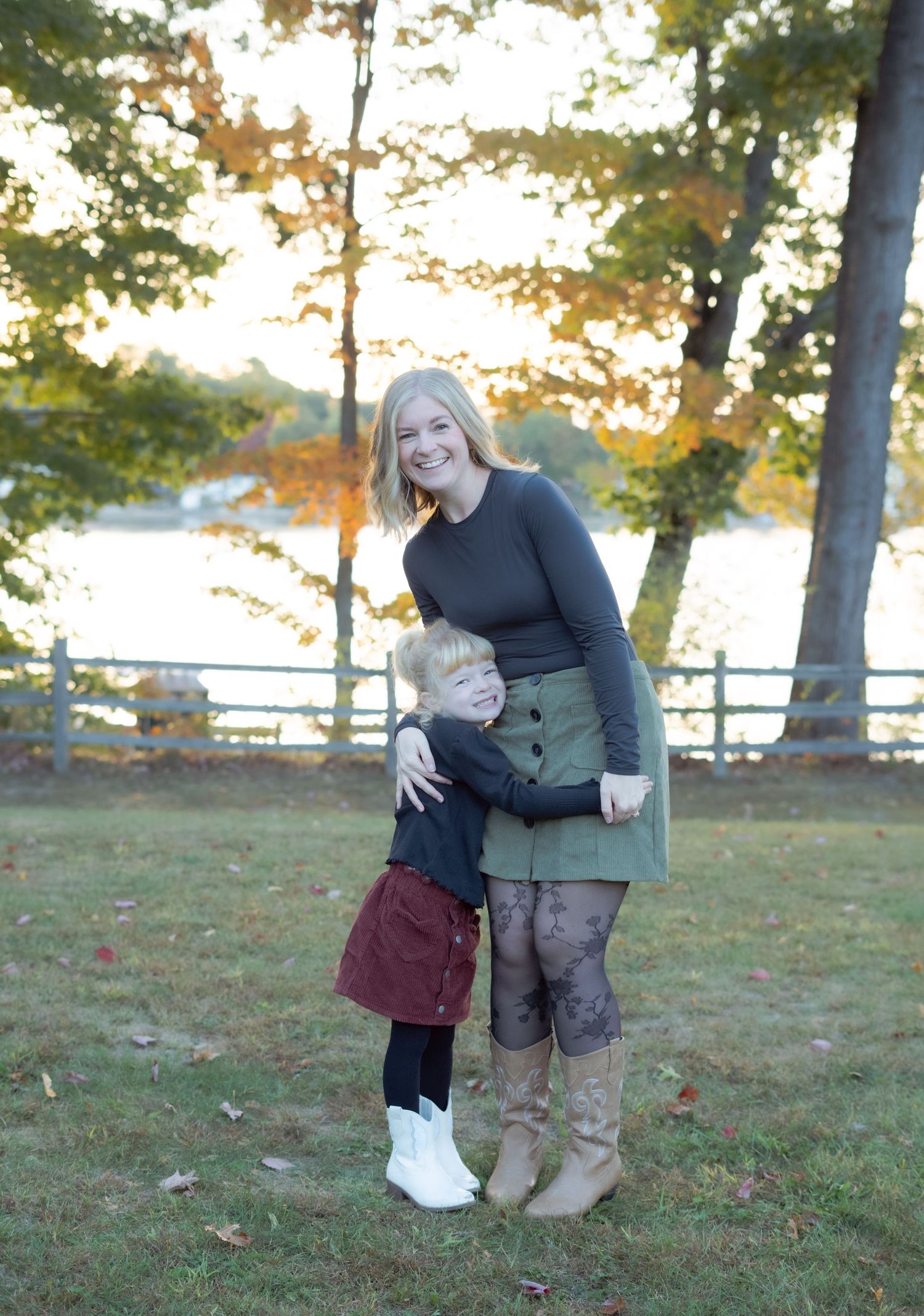 A sweet embrace shared between two during a fall photoshoot with water and trees in background.