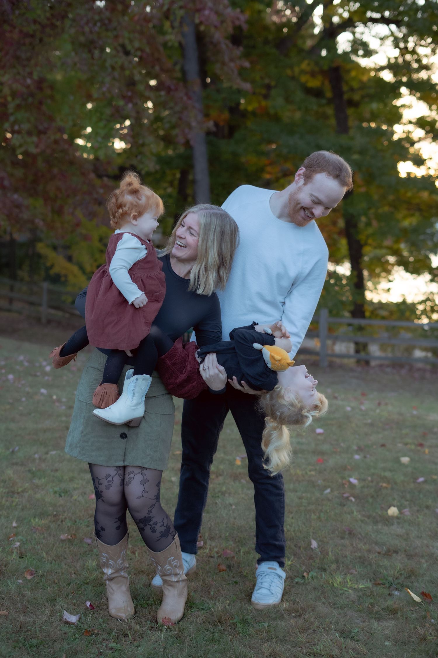 A joyful family having fun and playing outdoors during golden hour.