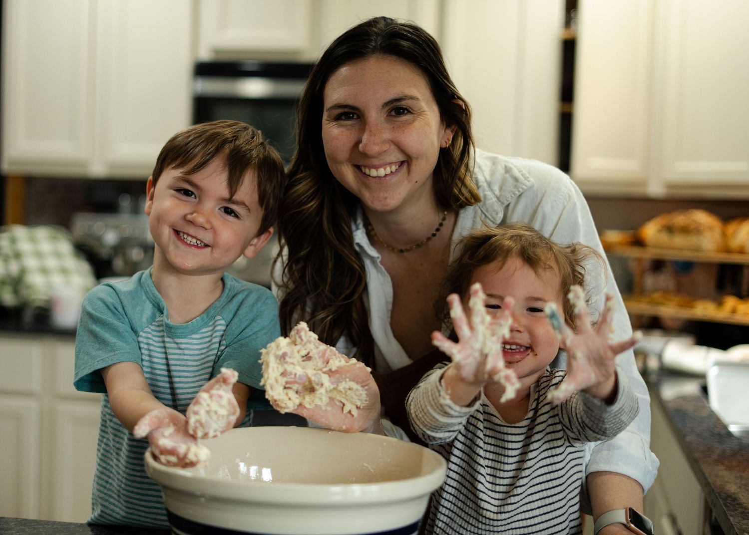 People enjoy a fun moment in the kitchen while making dessert together and sharing smiles around a mixing bowl.