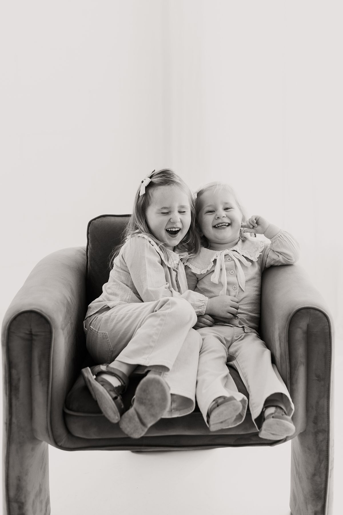 Four black and white photos capturing heartwarming laughter and bonding moments on a dark couch.