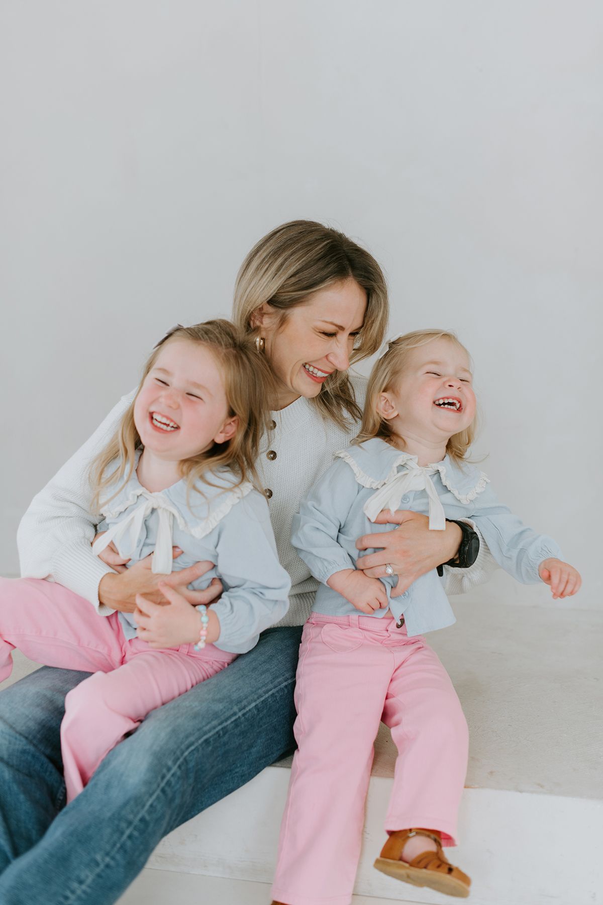 Four sequential photos show a playful and joyful candid moment between parent and child laughing together on a white couch.