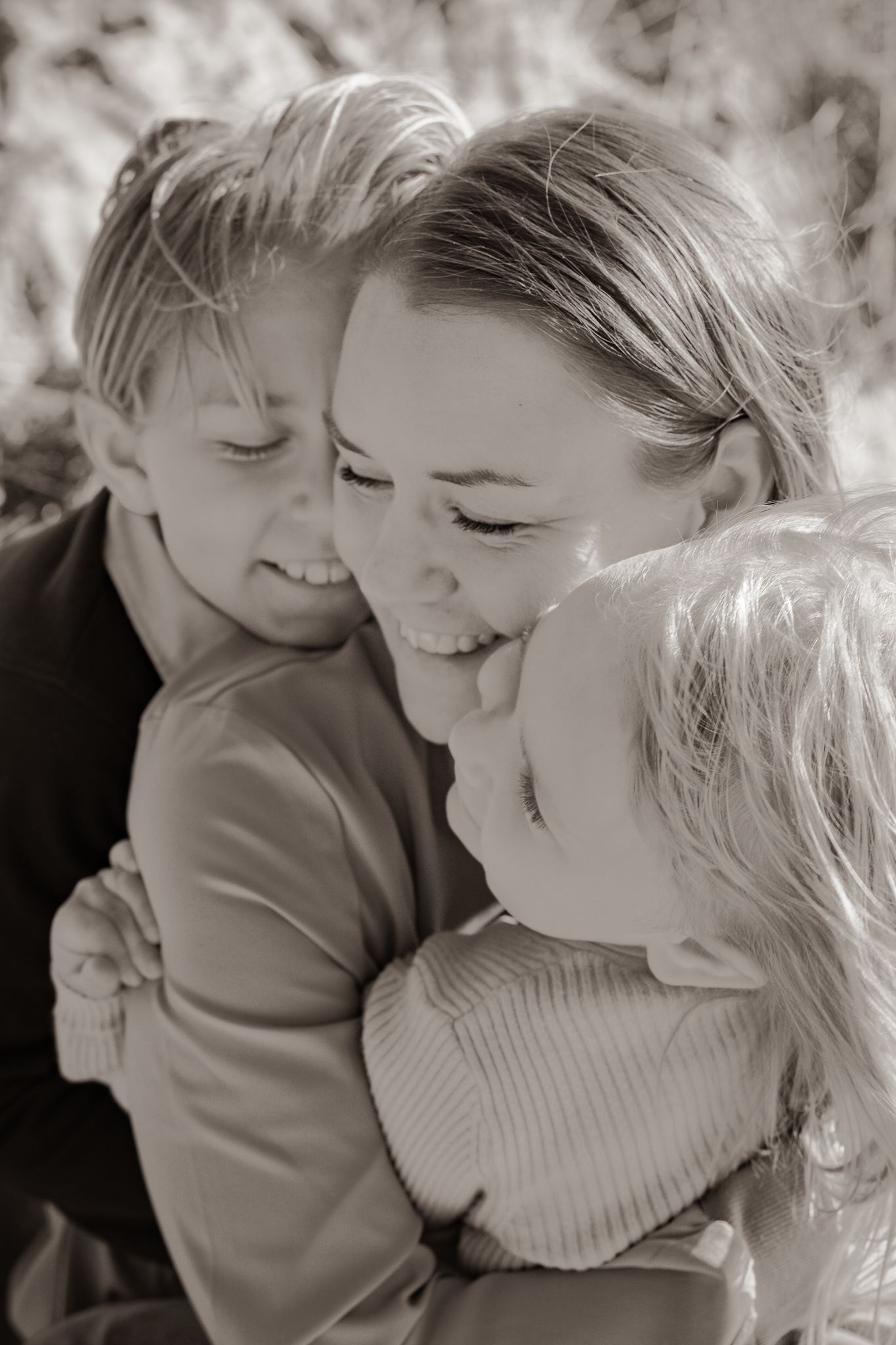 Svartvit kärleksfull varm närbild på mamma som kramas tätt med sina barn. Fotograf, familjefotograf, Umeå, Västerbotten