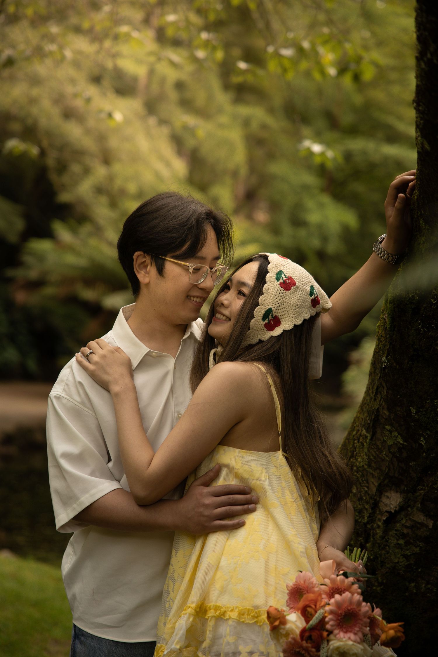 A tender embrace between a couple against a blurred forest background.