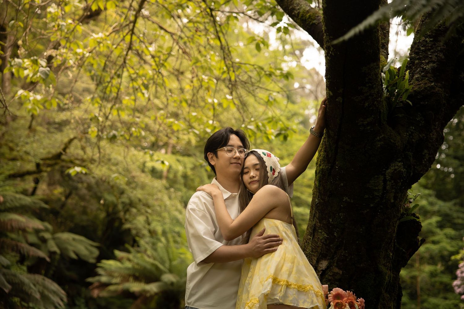 A series of romantic wedding photos captured against a rustic tree backdrop in warm golden lighting.