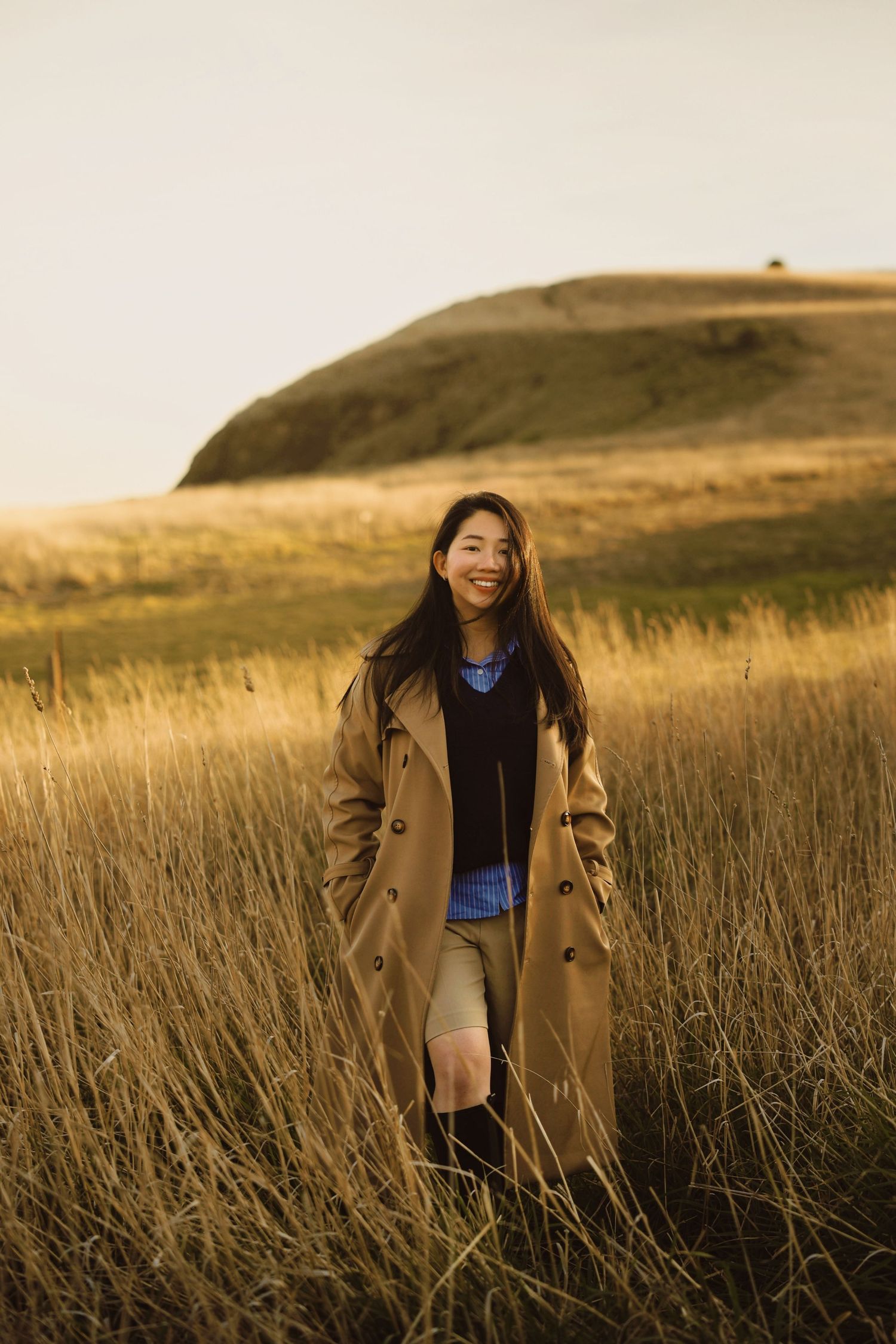 A sequence of dreamy photos showing someone in a tan coat walking through golden sunlit grass in a field at sunset.