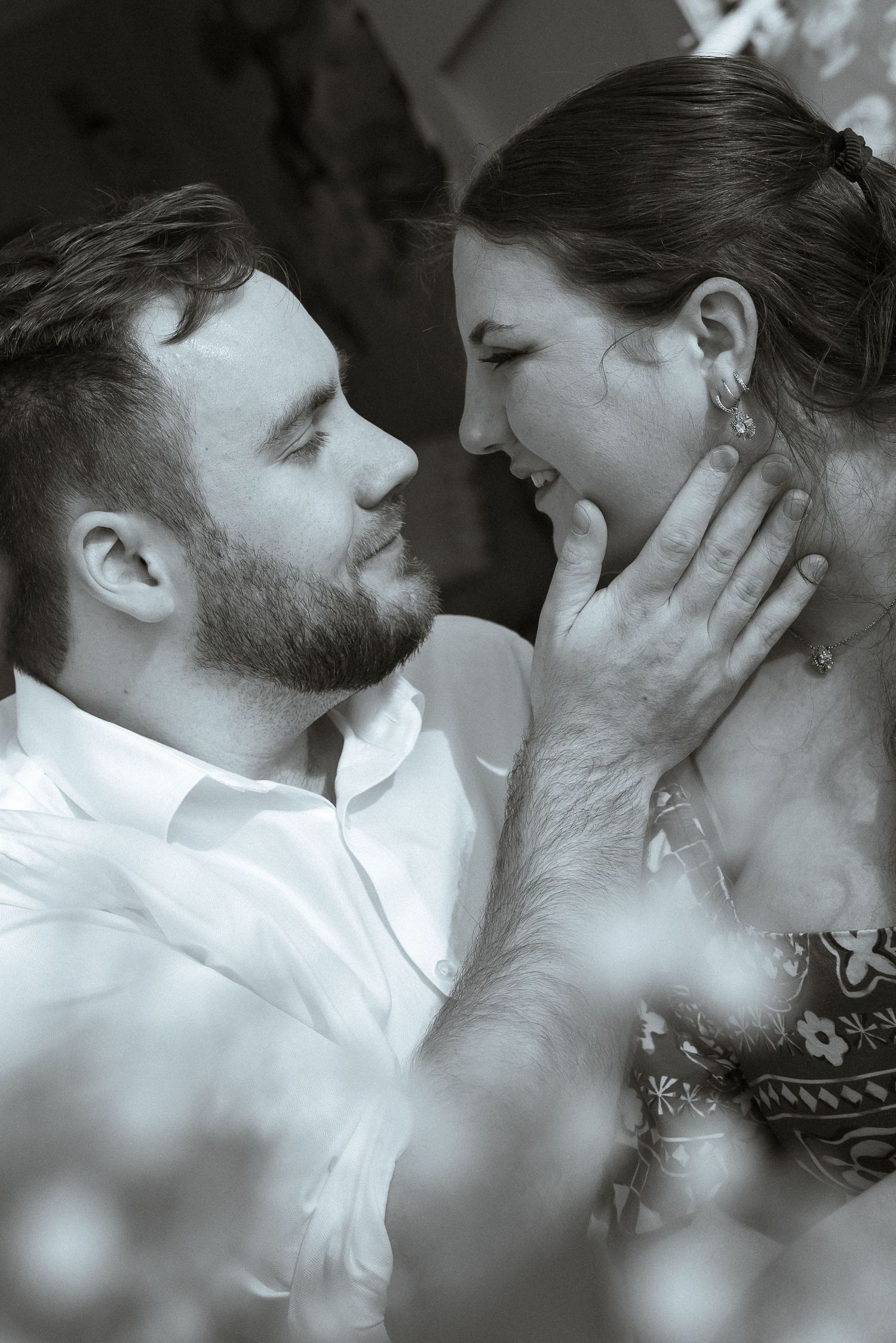 A romantic black and white photo series showing a couple in intimate close-up moments sharing tender kisses.