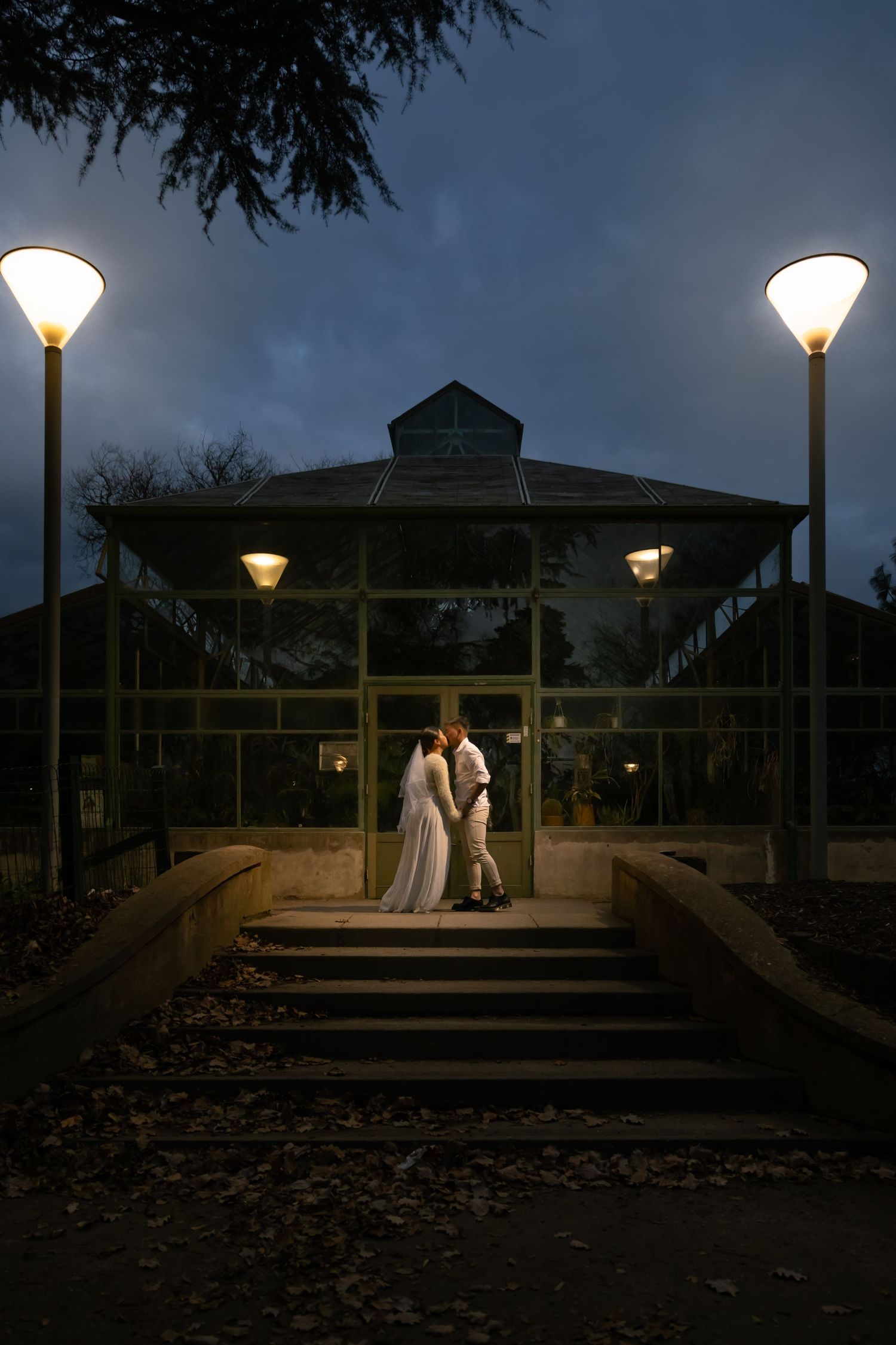 A romantic evening scene of a couple sharing a tender moment on a dimly lit gazebo deck at dusk.