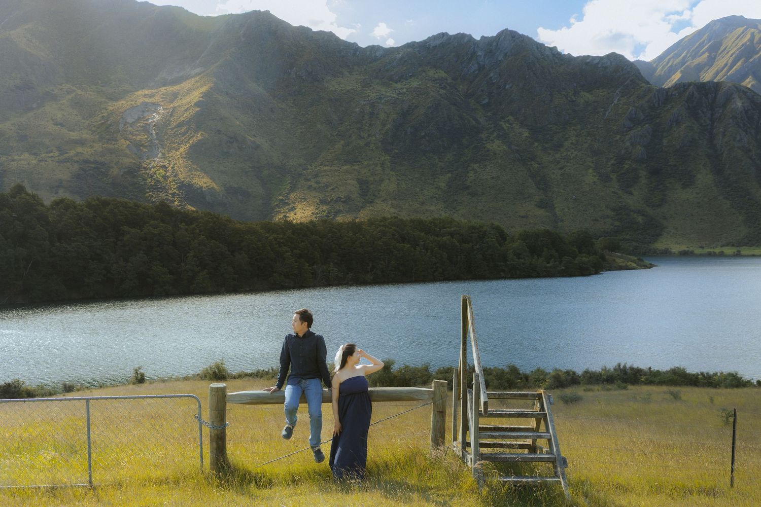 Scenic panoramic view of rolling mountains and green meadows under a cloudy sky in New Zealand.