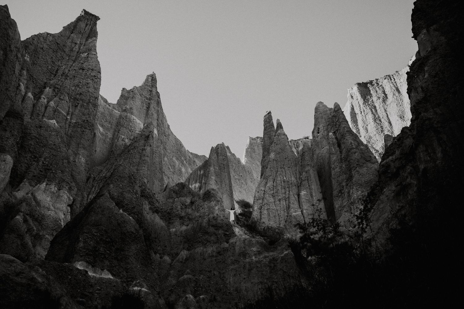 Black and white landscape of dramatic jagged clay pinnacle formations reaching into the sky.