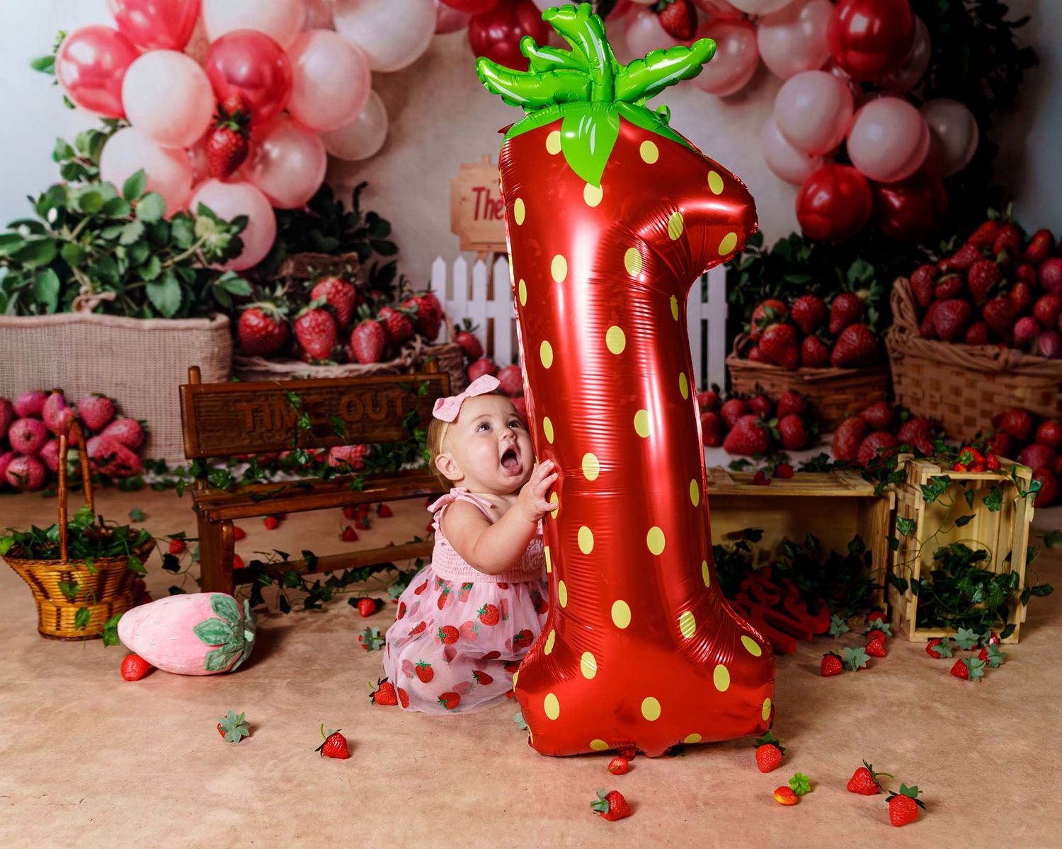 Baby's first birthday cake smash with strawberry number one balloon and strawberry themed decor.