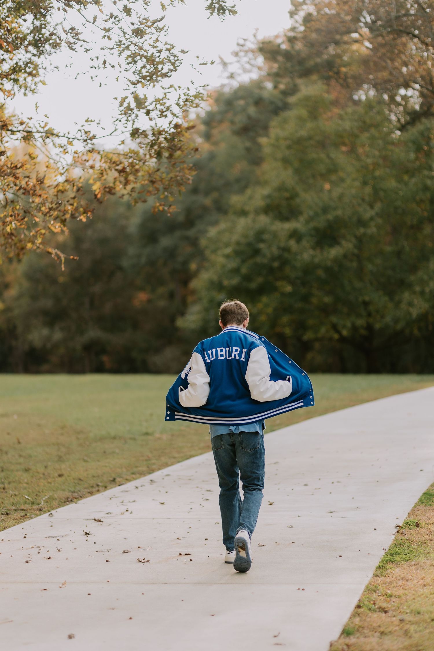 Graduate celebrating during a portrait session in Auburn, Alabama with a fun, candid and joyful vibe