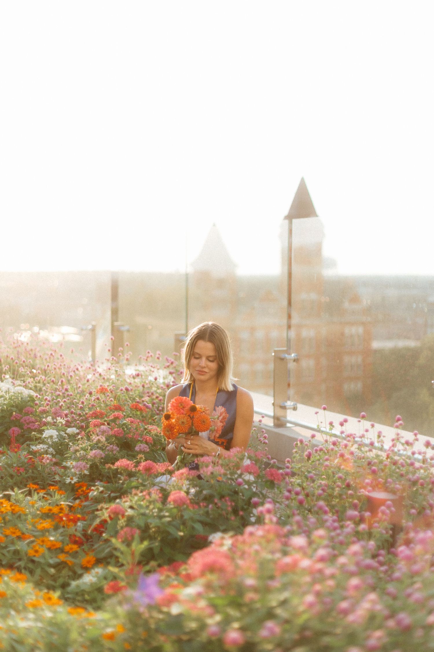 Graduate celebrating during a portrait session in Walt's on The Roof in Auburn, Alabama with a fun, candid and joyful vibe