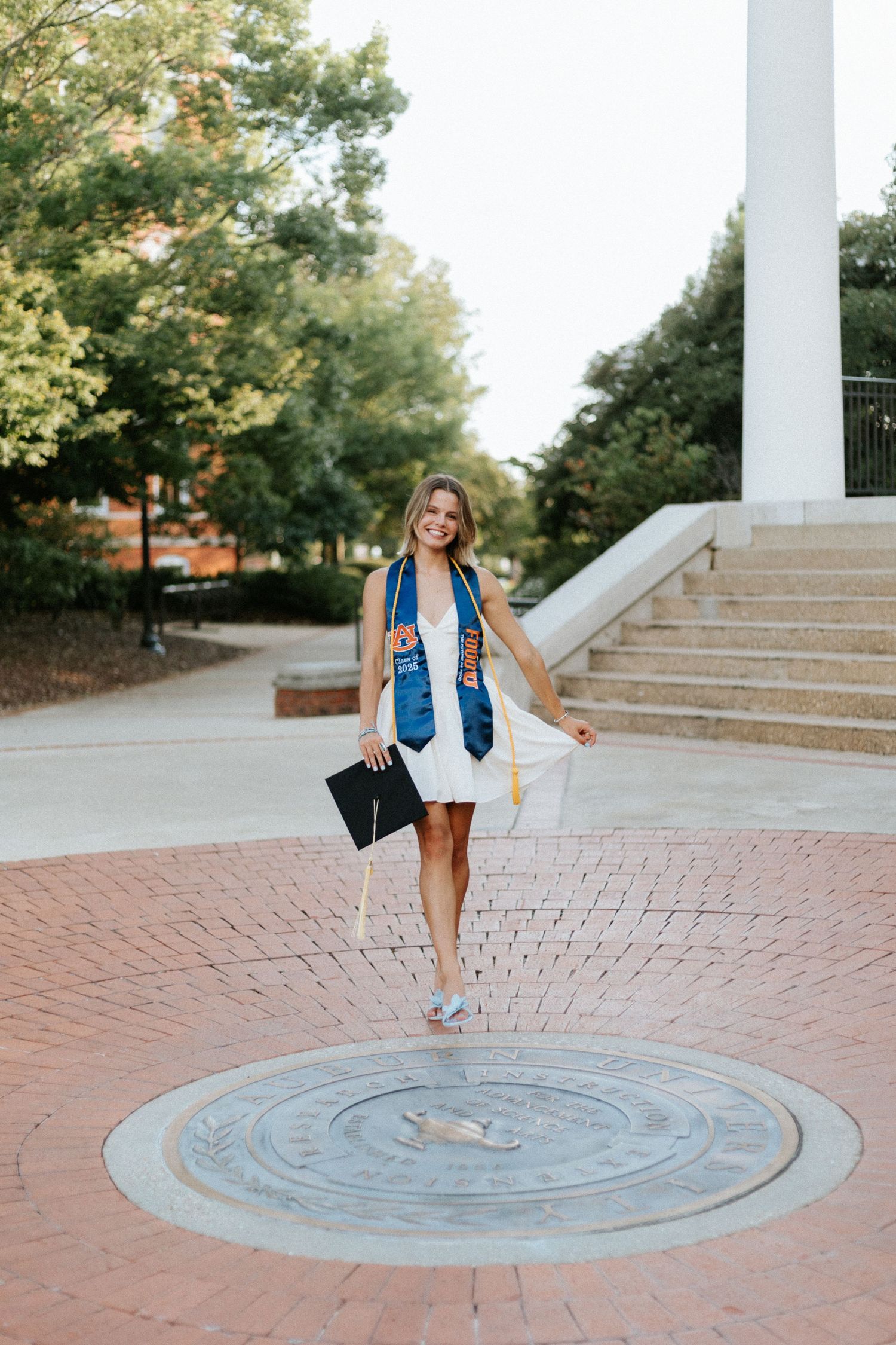 Graduate celebrating during a portrait session in Auburn, Alabama with a fun, candid and joyful vibe