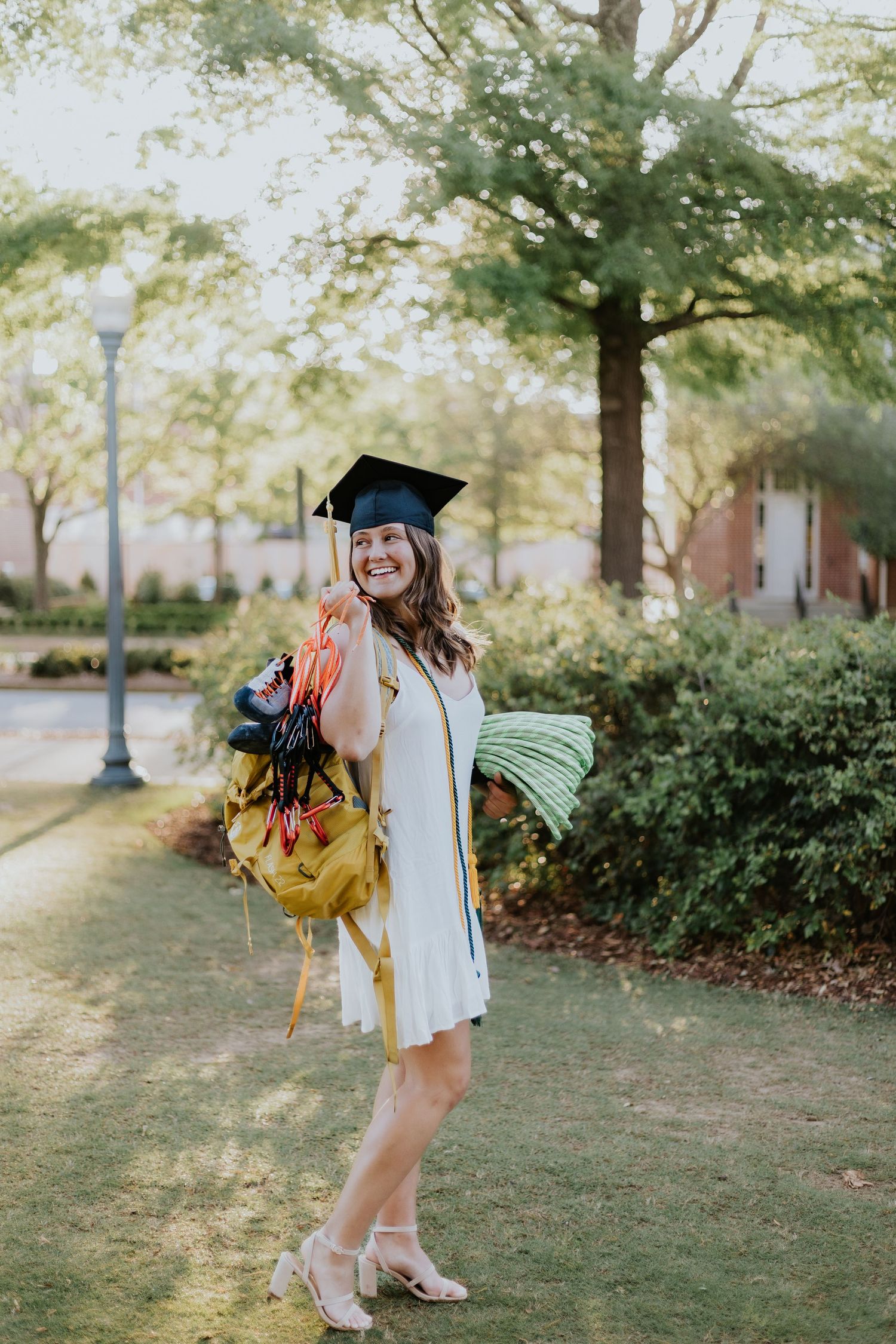 Graduate celebrating during a portrait session in Walt's on The Roof in Auburn, Alabama with a fun, candid and joyful vibe
