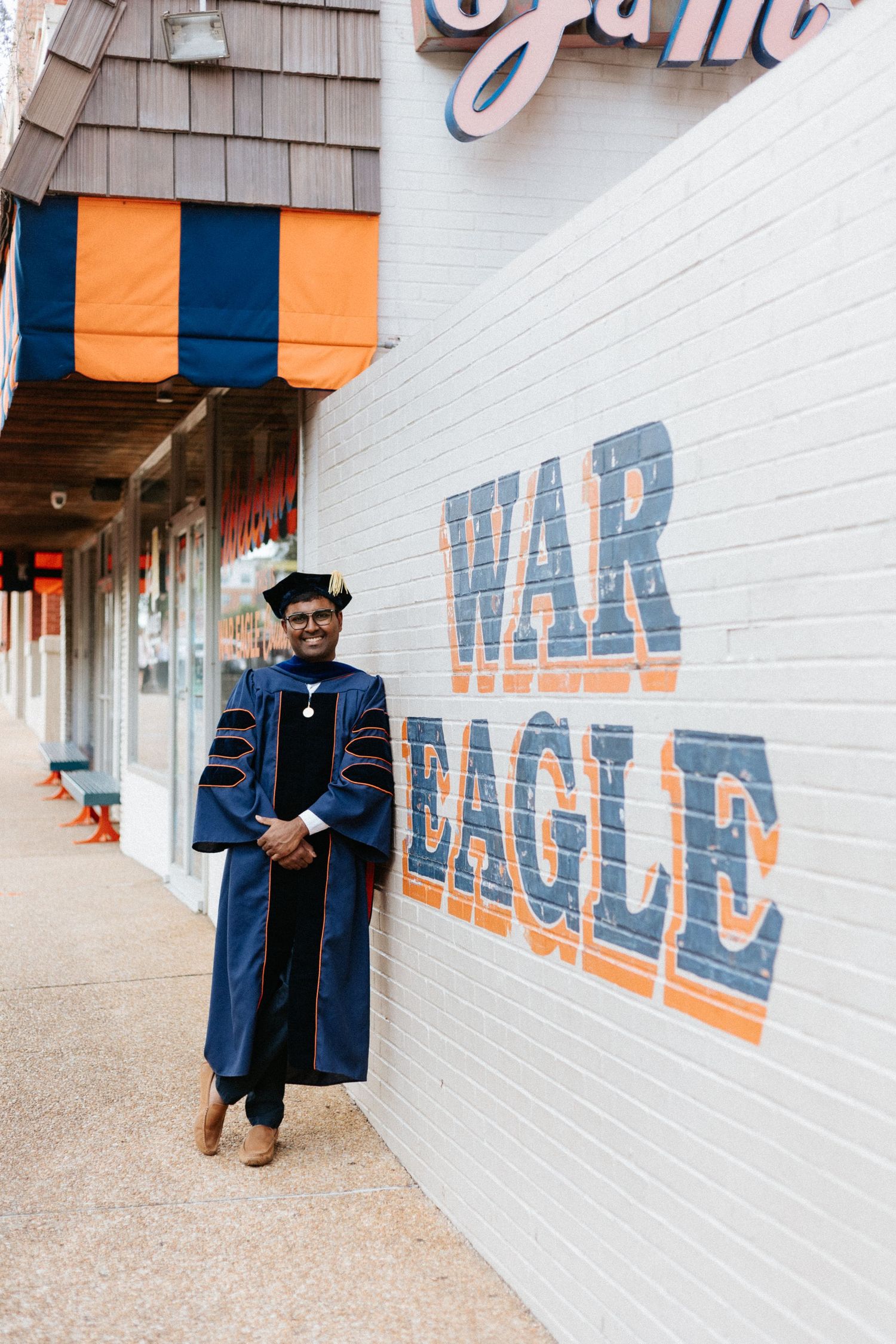 Graduate celebrating during a portrait session in Auburn, Alabama with a fun, candid and joyful vibe