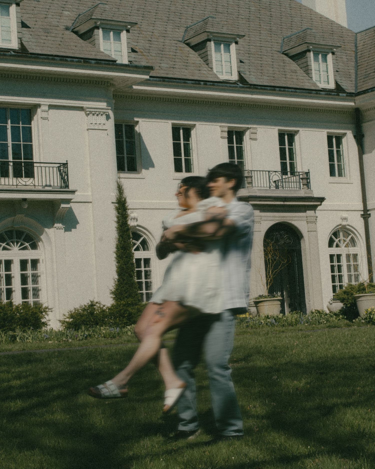 Romantic couple framed by grand estate architecture, creating a timeless and editorial luxury portrait