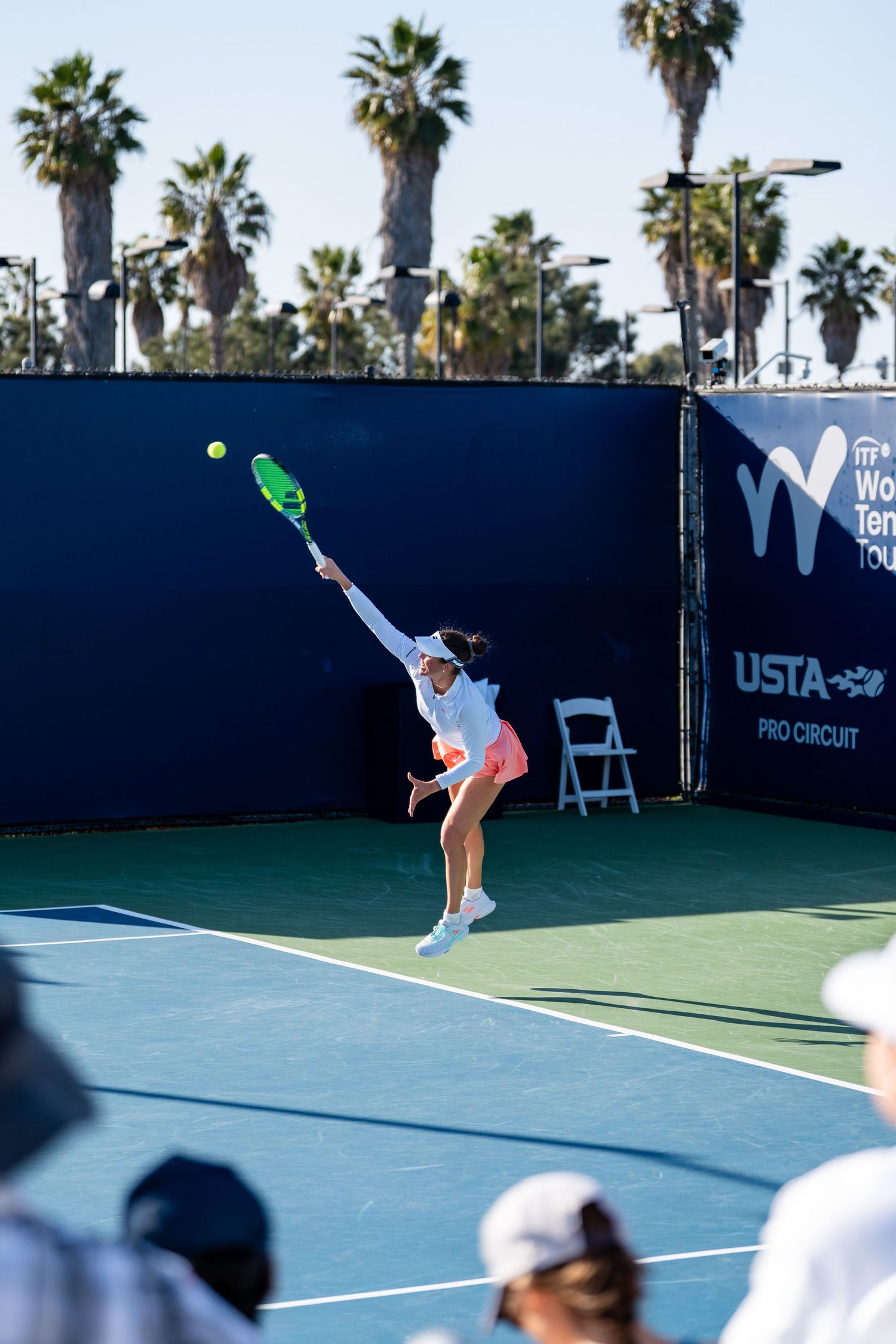 Female tennis player serving at a USTA Pro Circuit WTA World Tennis Tour match on an outdoor hard court.