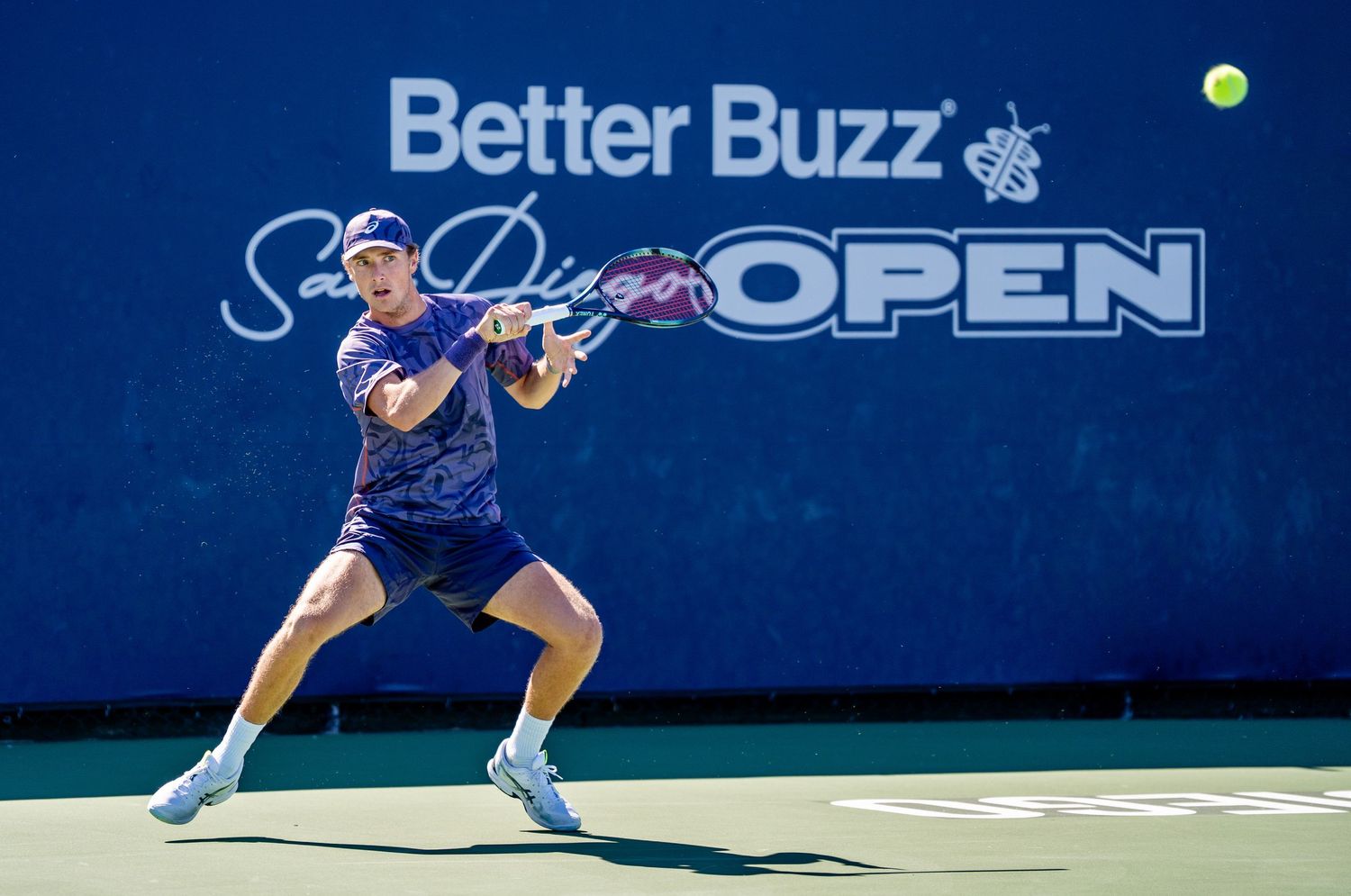 Tennis player hitting forehand at Better Buzz San Diego Open on outdoor hard court.