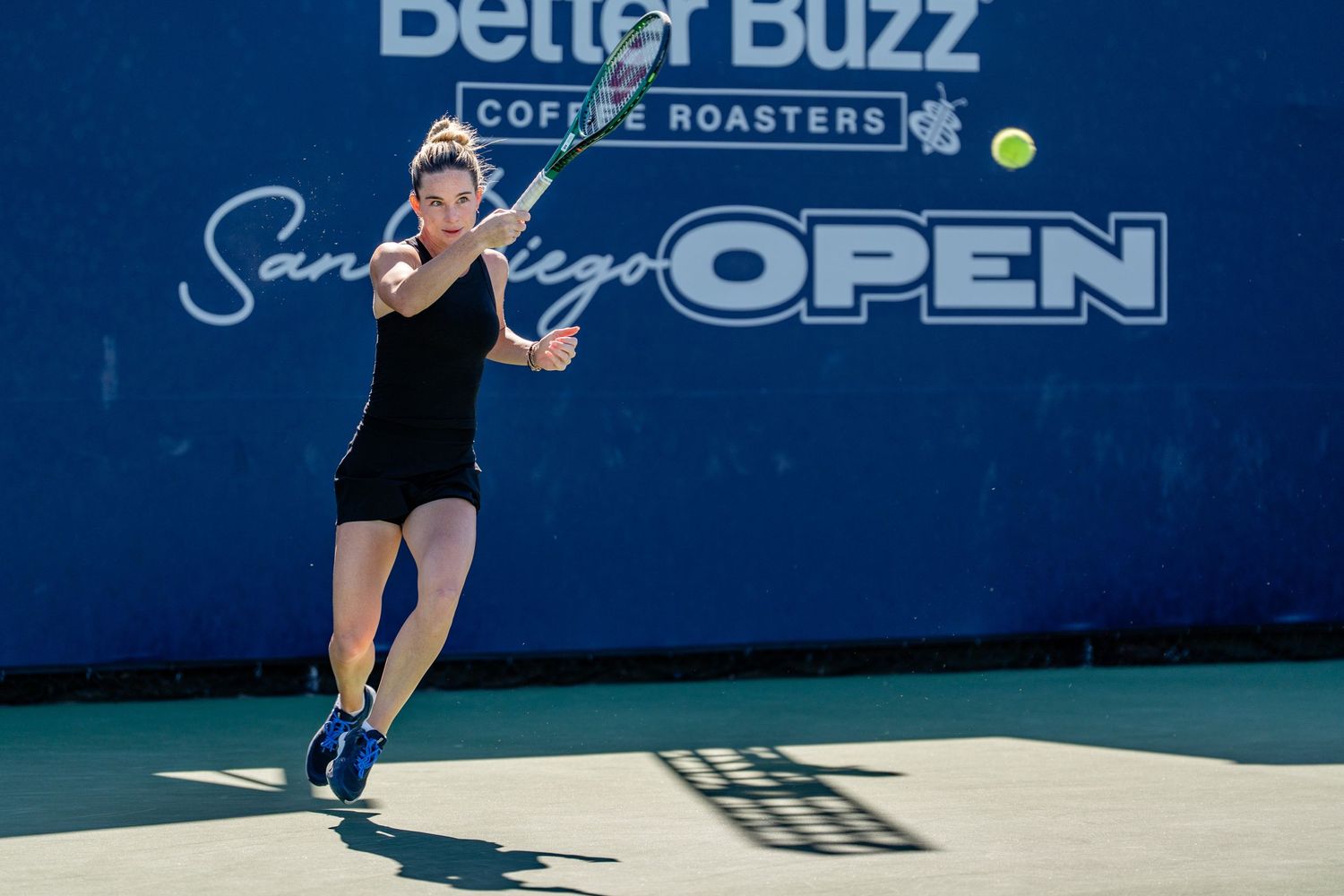Female tennis player hits a forehand shot at the Better Buzz Coffee Roasters San Diego Open tournament.