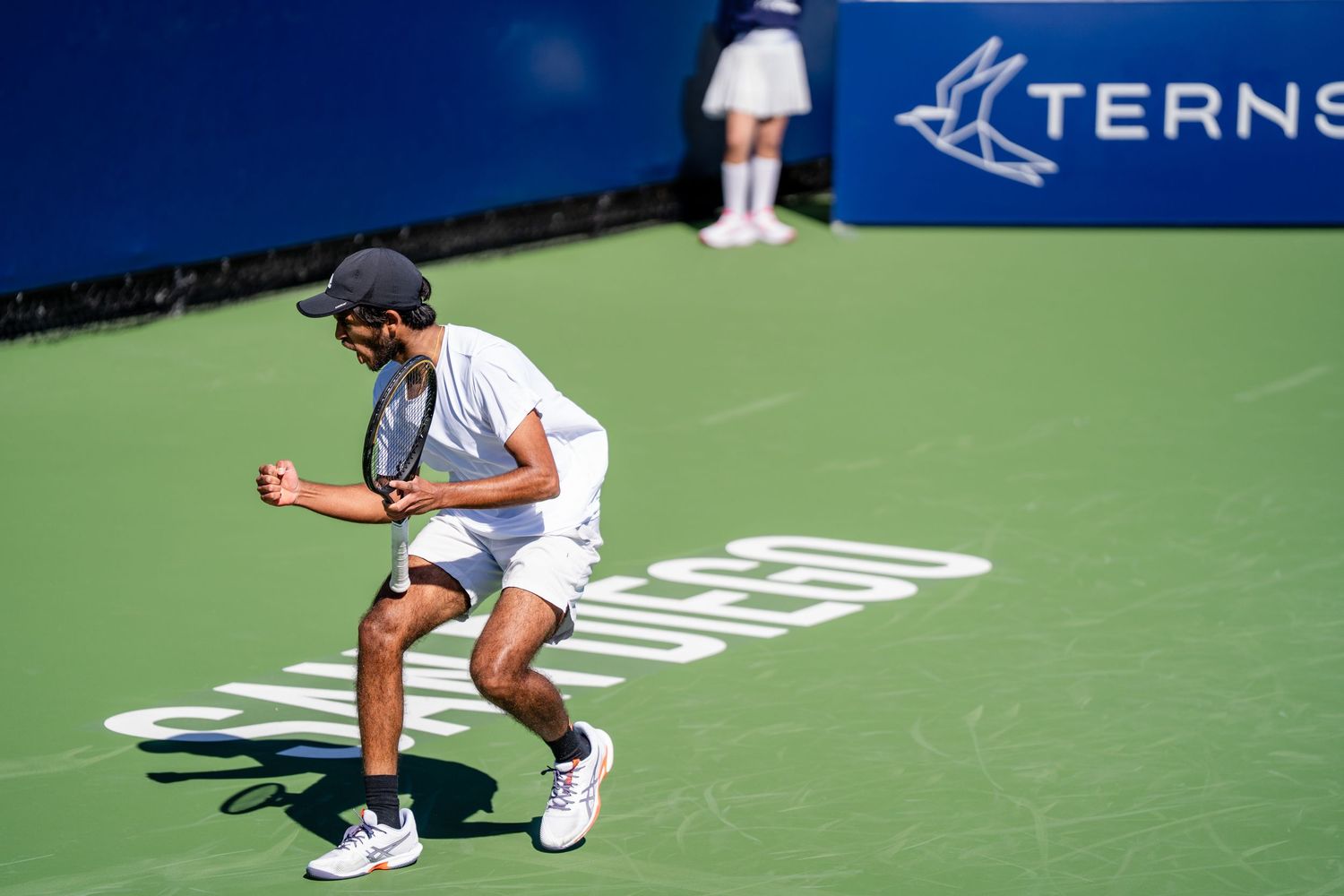 Tennis player celebrates a winning point on a hard court with Terns sponsorship branding visible.