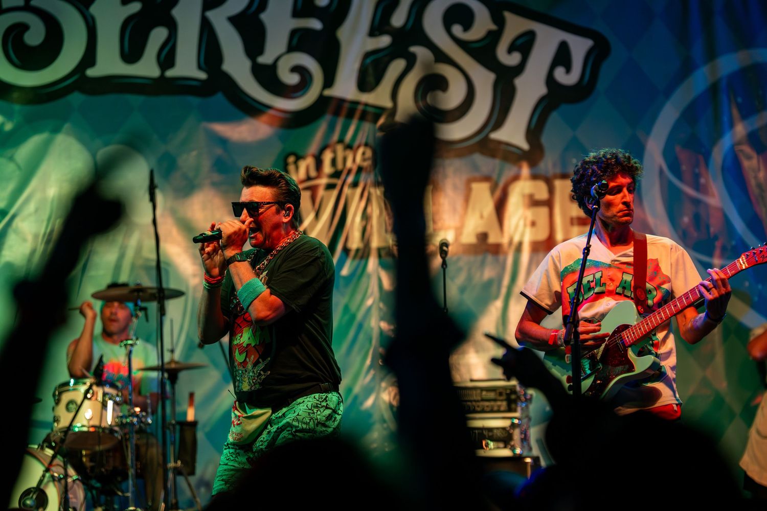 Rock band performs energetically on stage at Surfest In The Village music festival.