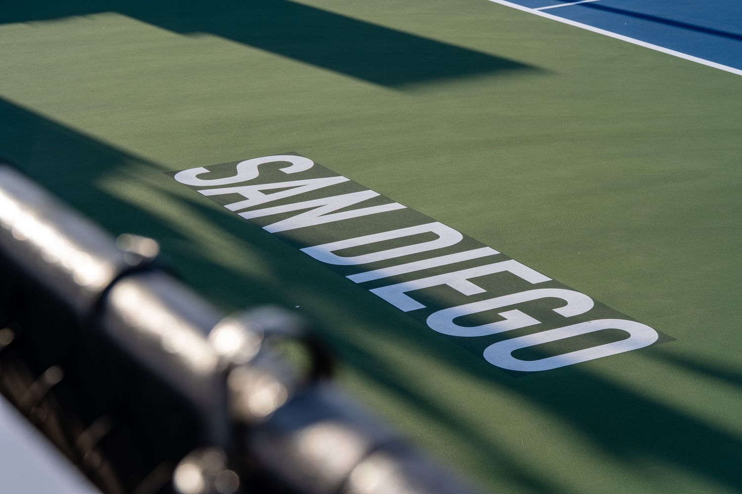 Close-up of San Diego text on a green tennis court surface with shallow depth of field.