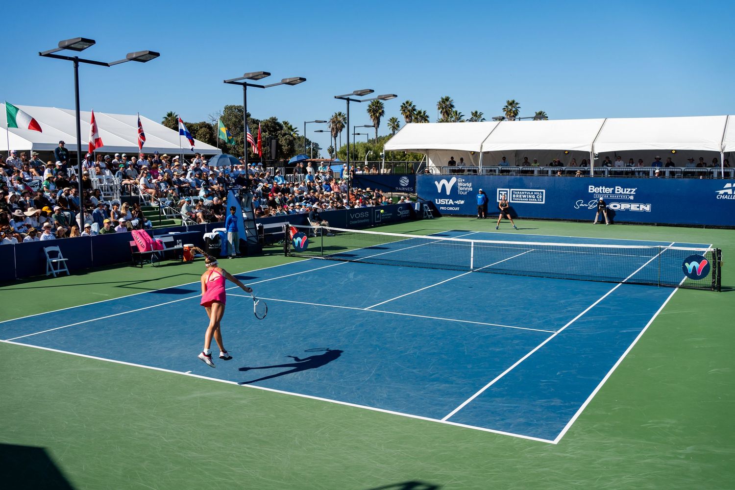 Aerial view of a professional women's tennis match on a blue court at the ITF World Tennis Tour event in San Diego.