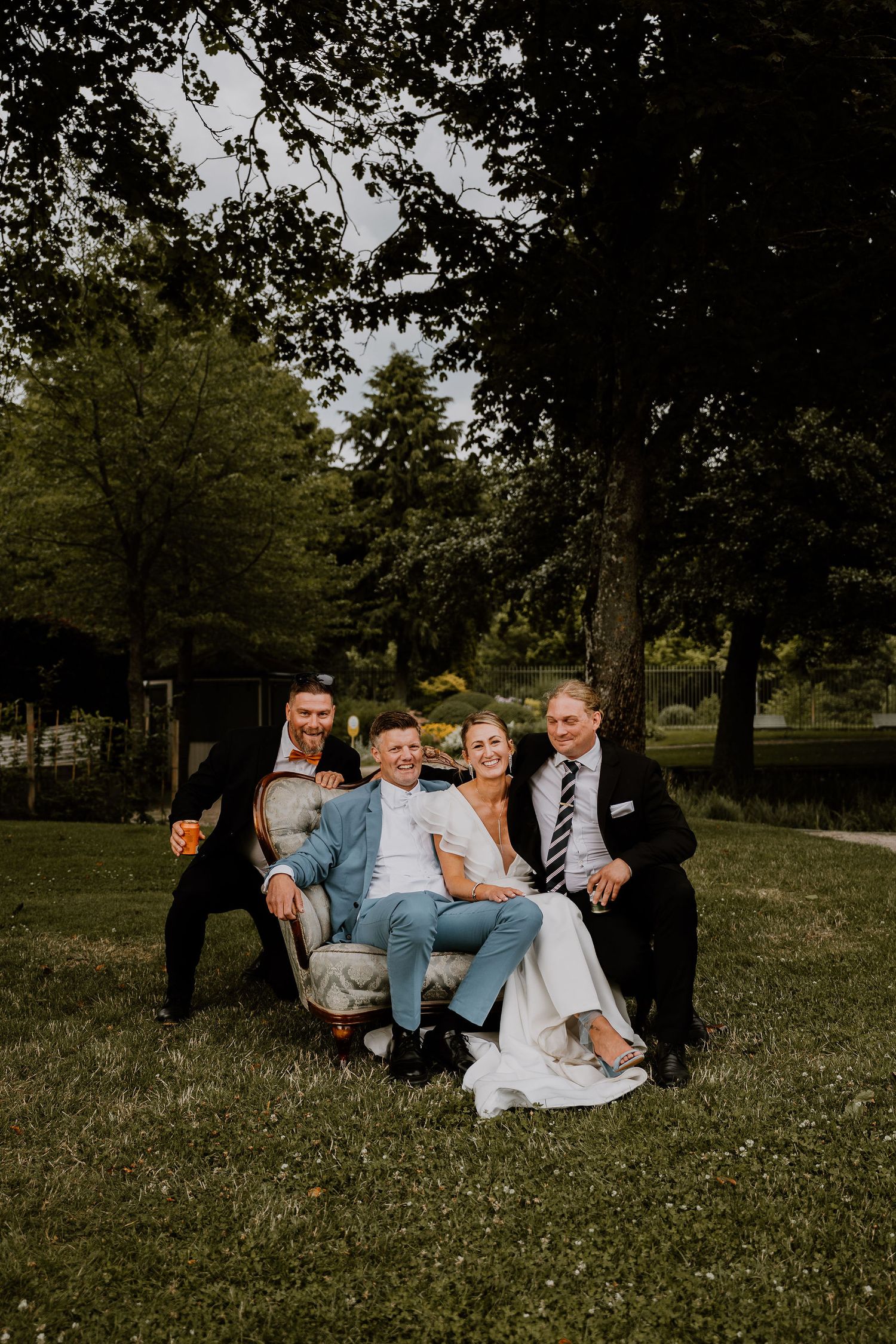 A candid progression of photos shows a playful moment of people lounging together on grass in a park setting.