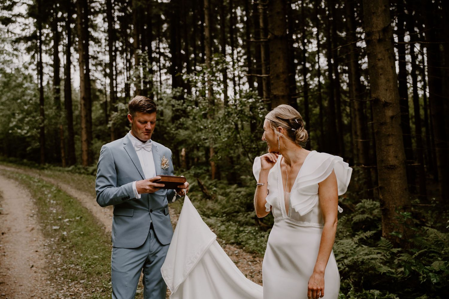 An elegant outdoor wedding ceremony with couple embracing in a lush forest setting, decorated with romantic details.