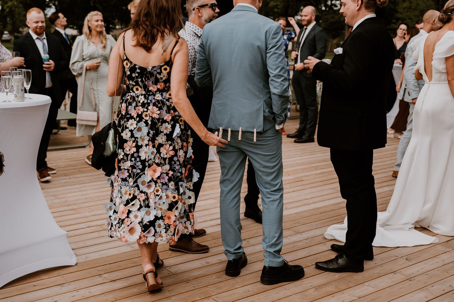 People dancing together on a wooden dance floor at a wedding reception enjoying the celebration.