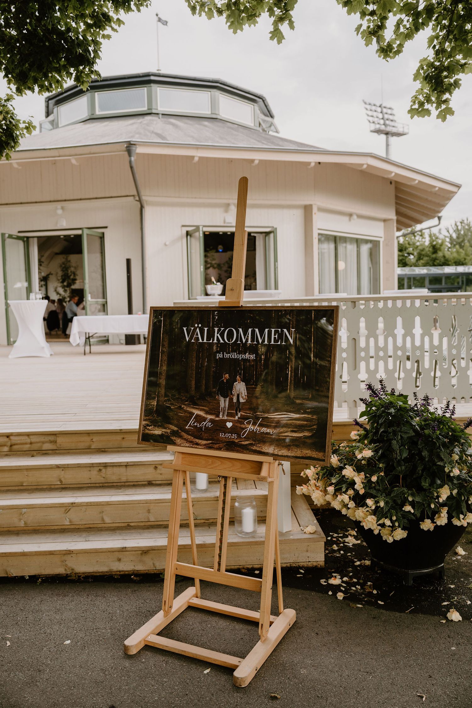 A rustic wooden welcome sign in Swedish 