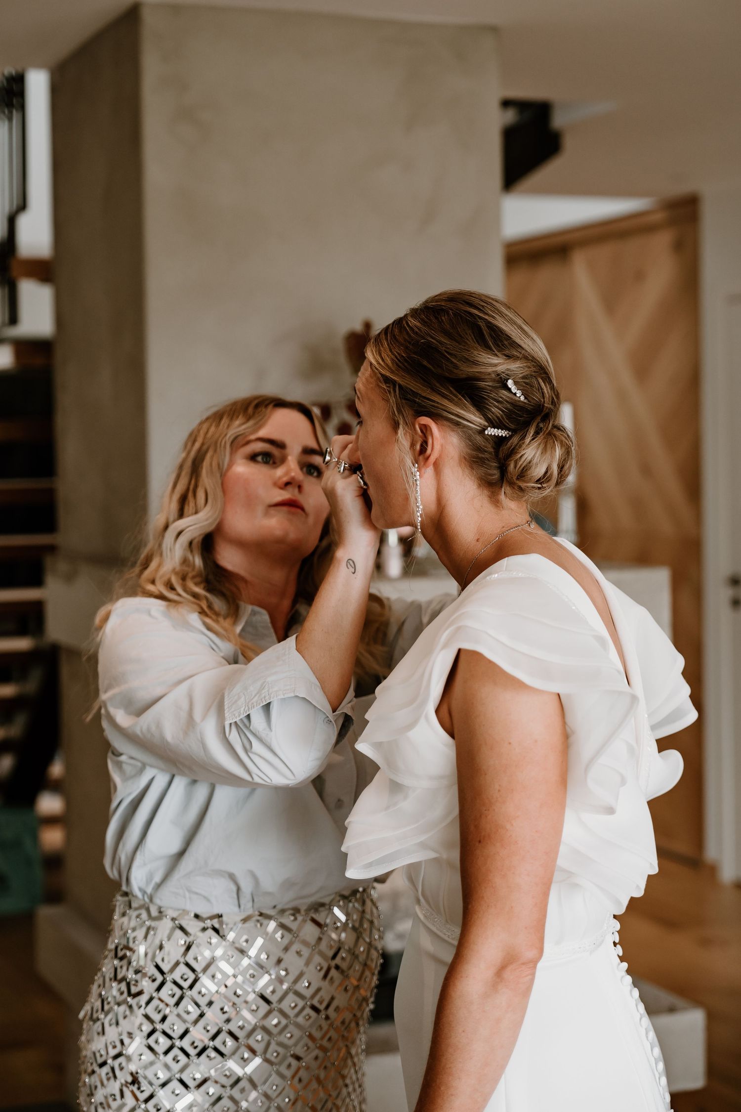 A tender moment shared between two people in white outfits embracing and dancing together in intimate wedding photos.