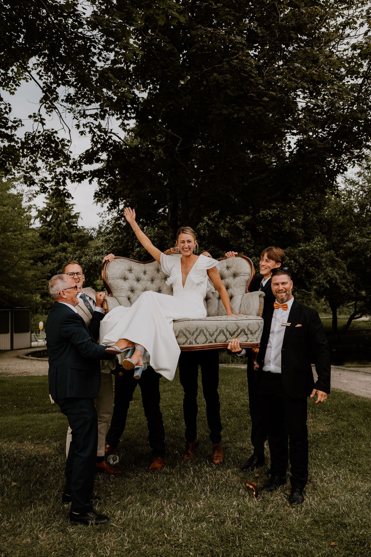 A series of wedding party members lifting one person horizontally in a fun outdoor celebratory pose sequence.